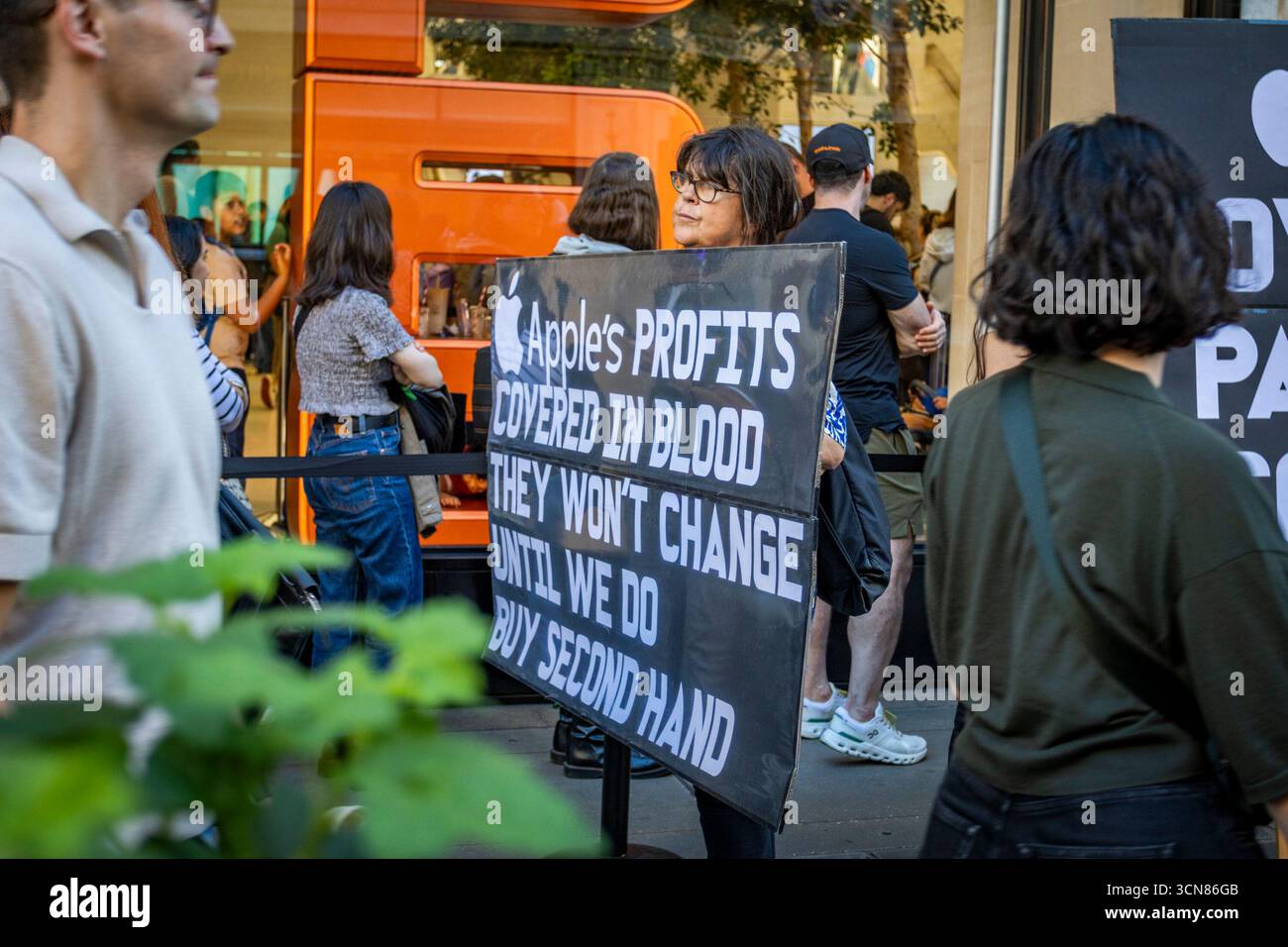 Aktivisten veranstalteten am 17. September einen Protest vor dem Apple Store in der Regent Street, Central London, während des Launch des iPhone 17. Demonstranten hielten Plakate, auf denen sie erklärten, dass das iPhone 17 mit Blut bedeckt ist, und beschuldigten Apple, vom Kobaltbergbau im Kongo im Zusammenhang mit Kinderarbeit und Menschenrechtsverletzungen profitiert zu haben. Die Warteschlangen von Kunden, die versuchten, den Regent Street Apple Store zu betreten, wurden mit Gesängen, Plakaten und Zuschauern getroffen, die sich versammelten, um den Protest zu beobachten. Stockfoto
