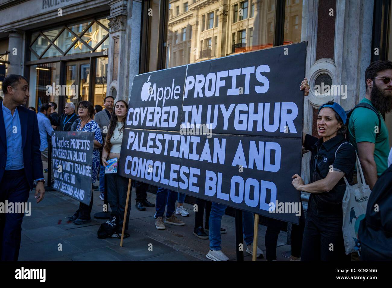 Aktivisten veranstalteten am 17. September einen Protest vor dem Apple Store in der Regent Street, Central London, während des Launch des iPhone 17. Demonstranten hielten Plakate, auf denen sie erklärten, dass das iPhone 17 mit Blut bedeckt ist, und beschuldigten Apple, vom Kobaltbergbau im Kongo im Zusammenhang mit Kinderarbeit und Menschenrechtsverletzungen profitiert zu haben. Die Warteschlangen von Kunden, die versuchten, den Regent Street Apple Store zu betreten, wurden mit Gesängen, Plakaten und Zuschauern getroffen, die sich versammelten, um den Protest zu beobachten. Stockfoto