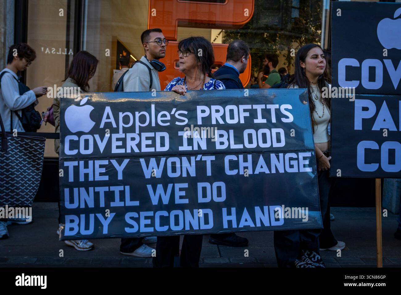 Aktivisten veranstalteten am 17. September einen Protest vor dem Apple Store in der Regent Street, Central London, während des Launch des iPhone 17. Demonstranten hielten Plakate, auf denen sie erklärten, dass das iPhone 17 mit Blut bedeckt ist, und beschuldigten Apple, vom Kobaltbergbau im Kongo im Zusammenhang mit Kinderarbeit und Menschenrechtsverletzungen profitiert zu haben. Die Warteschlangen von Kunden, die versuchten, den Regent Street Apple Store zu betreten, wurden mit Gesängen, Plakaten und Zuschauern getroffen, die sich versammelten, um den Protest zu beobachten. Stockfoto