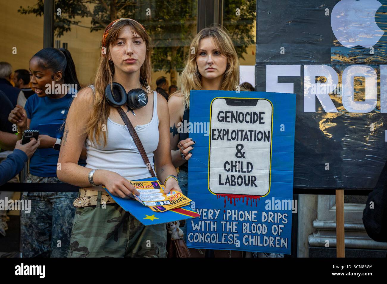 Aktivisten veranstalteten am 17. September einen Protest vor dem Apple Store in der Regent Street, Central London, während des Launch des iPhone 17. Demonstranten hielten Plakate, auf denen sie erklärten, dass das iPhone 17 mit Blut bedeckt ist, und beschuldigten Apple, vom Kobaltbergbau im Kongo im Zusammenhang mit Kinderarbeit und Menschenrechtsverletzungen profitiert zu haben. Die Warteschlangen von Kunden, die versuchten, den Regent Street Apple Store zu betreten, wurden mit Gesängen, Plakaten und Zuschauern getroffen, die sich versammelten, um den Protest zu beobachten. Stockfoto