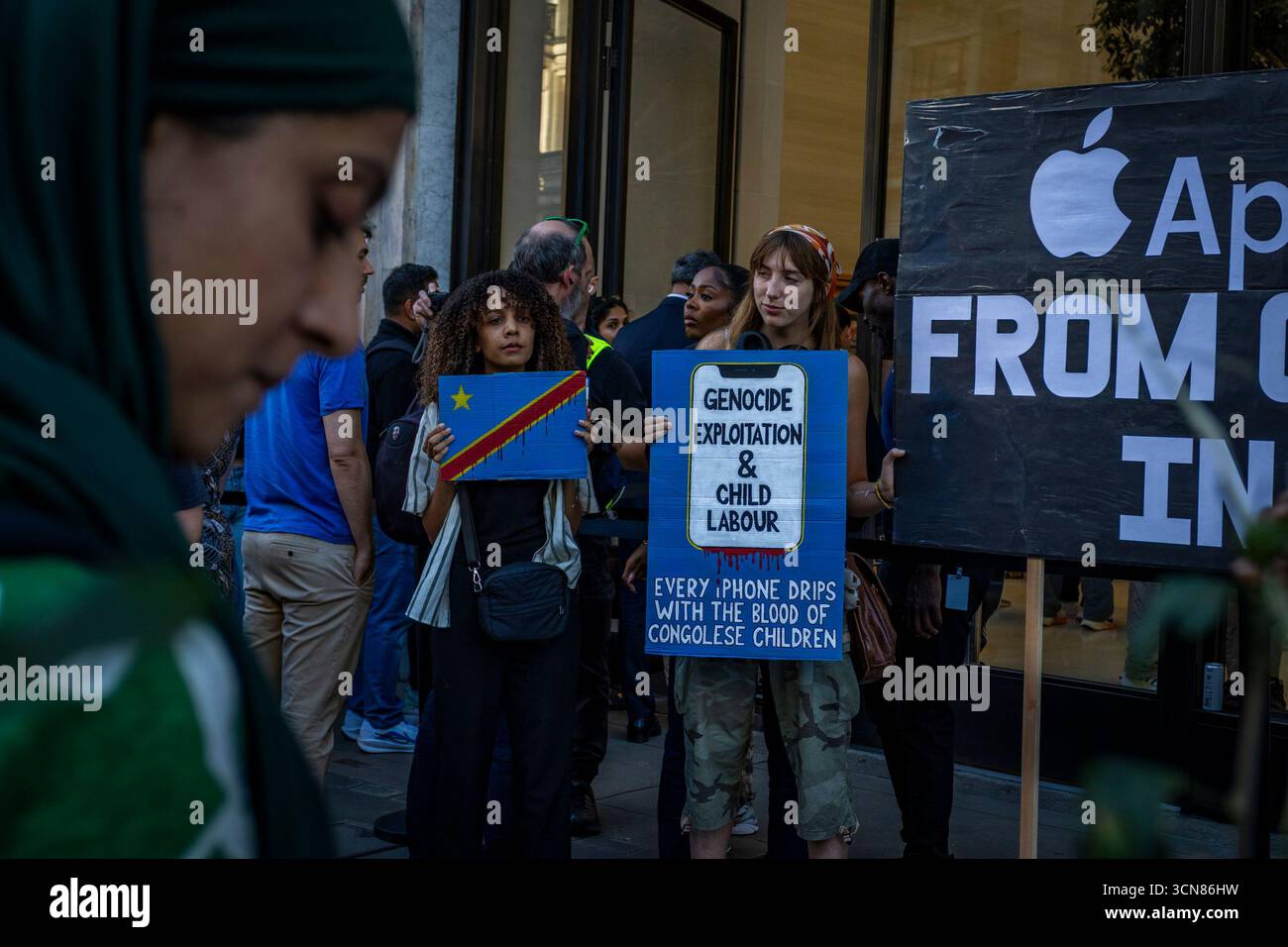 Aktivisten veranstalteten am 17. September einen Protest vor dem Apple Store in der Regent Street, Central London, während des Launch des iPhone 17. Demonstranten hielten Plakate, auf denen sie erklärten, dass das iPhone 17 mit Blut bedeckt ist, und beschuldigten Apple, vom Kobaltbergbau im Kongo im Zusammenhang mit Kinderarbeit und Menschenrechtsverletzungen profitiert zu haben. Die Warteschlangen von Kunden, die versuchten, den Regent Street Apple Store zu betreten, wurden mit Gesängen, Plakaten und Zuschauern getroffen, die sich versammelten, um den Protest zu beobachten. Stockfoto