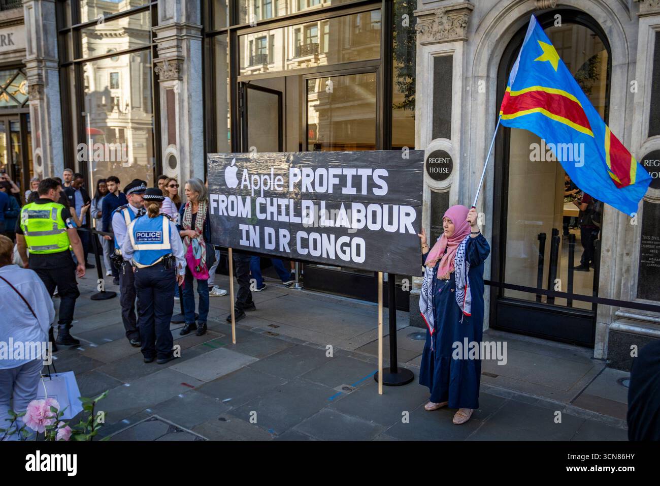 Aktivisten veranstalteten am 17. September einen Protest vor dem Apple Store in der Regent Street, Central London, während des Launch des iPhone 17. Demonstranten hielten Plakate, auf denen sie erklärten, dass das iPhone 17 mit Blut bedeckt ist, und beschuldigten Apple, vom Kobaltbergbau im Kongo im Zusammenhang mit Kinderarbeit und Menschenrechtsverletzungen profitiert zu haben. Die Warteschlangen von Kunden, die versuchten, den Regent Street Apple Store zu betreten, wurden mit Gesängen, Plakaten und Zuschauern getroffen, die sich versammelten, um den Protest zu beobachten. Stockfoto