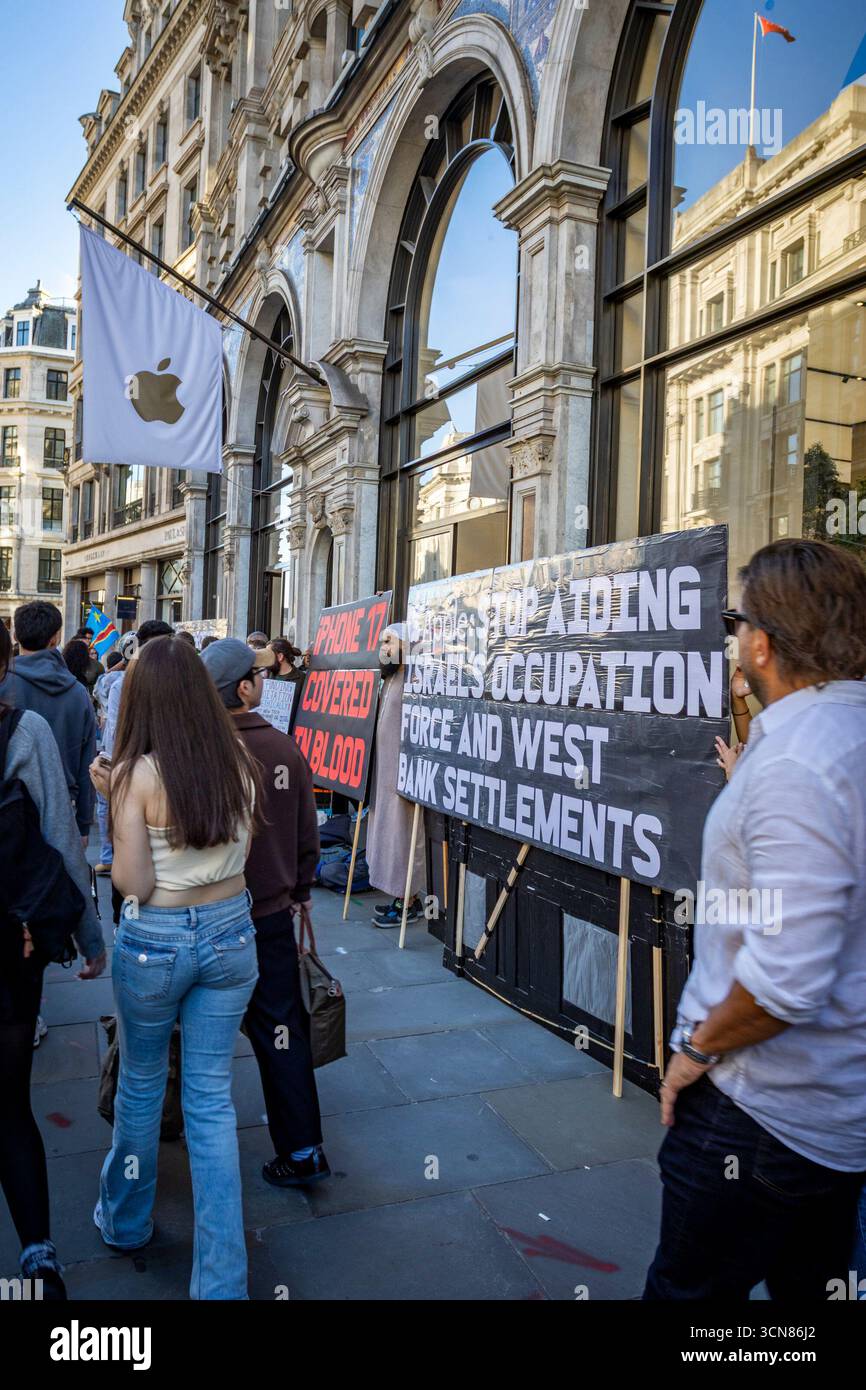 Aktivisten veranstalteten am 17. September einen Protest vor dem Apple Store in der Regent Street, Central London, während des Launch des iPhone 17. Demonstranten hielten Plakate, auf denen sie erklärten, dass das iPhone 17 mit Blut bedeckt ist, und beschuldigten Apple, vom Kobaltbergbau im Kongo im Zusammenhang mit Kinderarbeit und Menschenrechtsverletzungen profitiert zu haben. Die Warteschlangen von Kunden, die versuchten, den Regent Street Apple Store zu betreten, wurden mit Gesängen, Plakaten und Zuschauern getroffen, die sich versammelten, um den Protest zu beobachten. Stockfoto