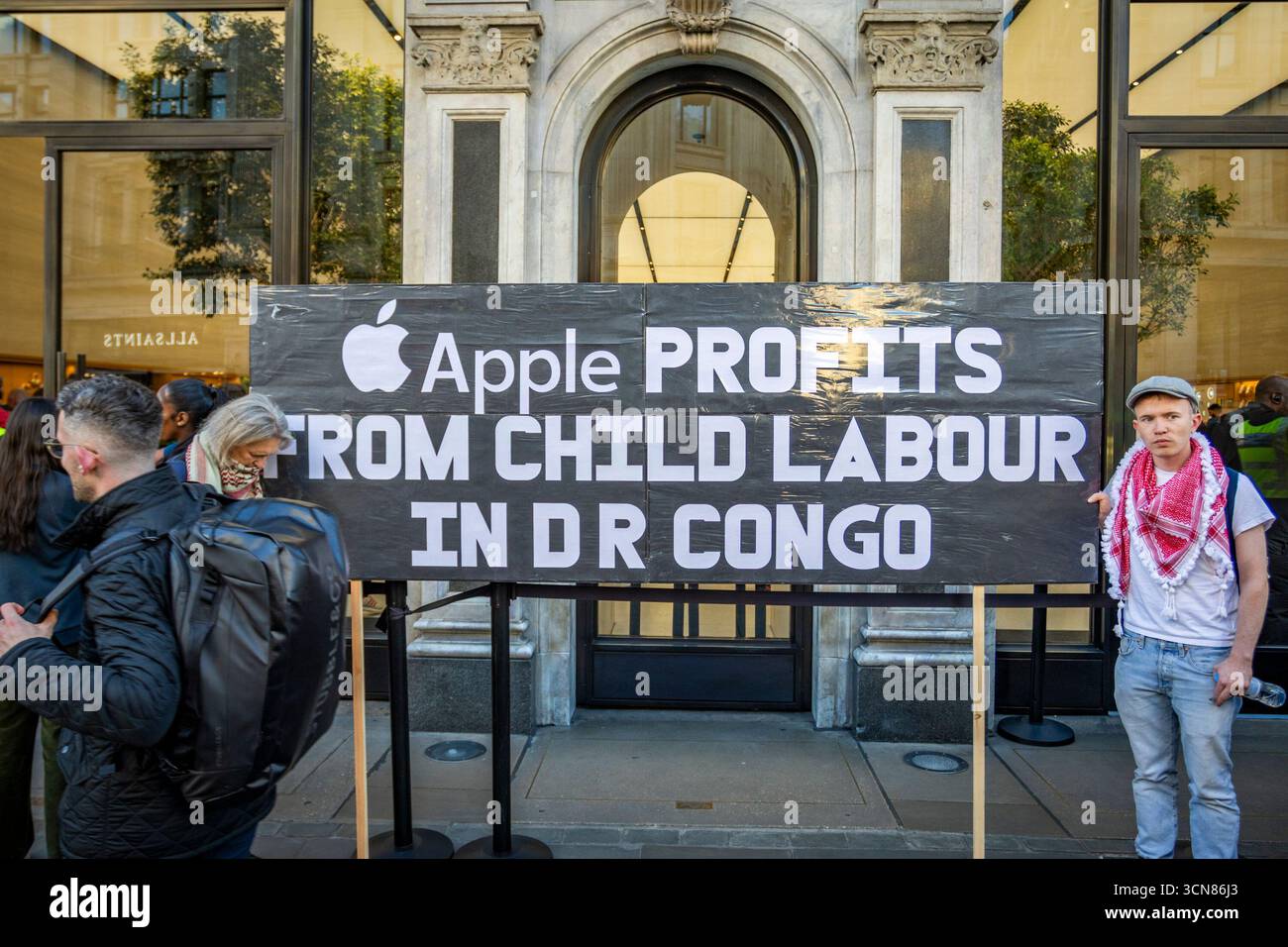 Aktivisten veranstalteten am 17. September einen Protest vor dem Apple Store in der Regent Street, Central London, während des Launch des iPhone 17. Demonstranten hielten Plakate, auf denen sie erklärten, dass das iPhone 17 mit Blut bedeckt ist, und beschuldigten Apple, vom Kobaltbergbau im Kongo im Zusammenhang mit Kinderarbeit und Menschenrechtsverletzungen profitiert zu haben. Die Warteschlangen von Kunden, die versuchten, den Regent Street Apple Store zu betreten, wurden mit Gesängen, Plakaten und Zuschauern getroffen, die sich versammelten, um den Protest zu beobachten. Stockfoto