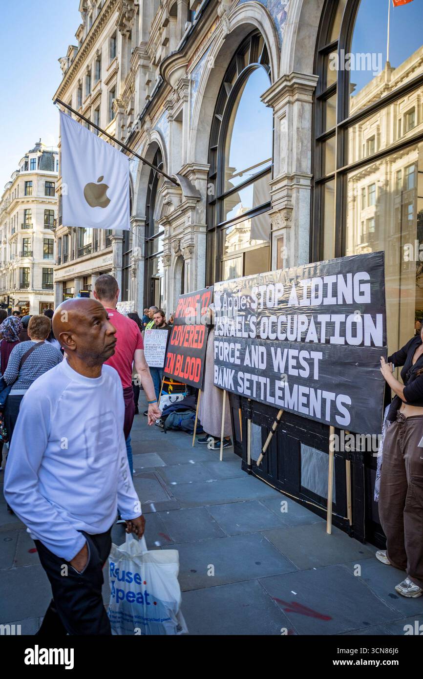 Aktivisten veranstalteten am 17. September einen Protest vor dem Apple Store in der Regent Street, Central London, während des Launch des iPhone 17. Demonstranten hielten Plakate, auf denen sie erklärten, dass das iPhone 17 mit Blut bedeckt ist, und beschuldigten Apple, vom Kobaltbergbau im Kongo im Zusammenhang mit Kinderarbeit und Menschenrechtsverletzungen profitiert zu haben. Die Warteschlangen von Kunden, die versuchten, den Regent Street Apple Store zu betreten, wurden mit Gesängen, Plakaten und Zuschauern getroffen, die sich versammelten, um den Protest zu beobachten. Stockfoto