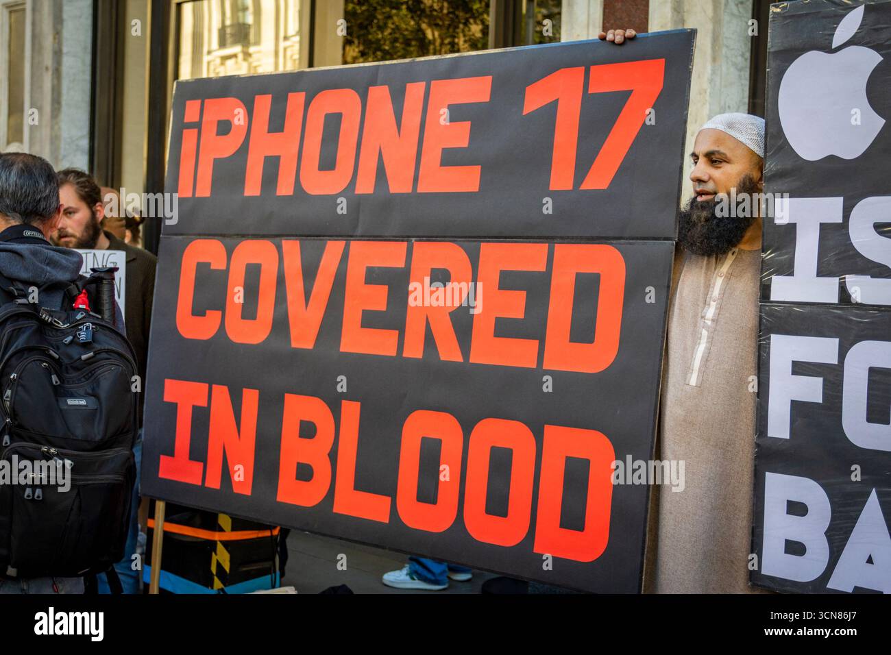 Aktivisten veranstalteten am 17. September einen Protest vor dem Apple Store in der Regent Street, Central London, während des Launch des iPhone 17. Demonstranten hielten Plakate, auf denen sie erklärten, dass das iPhone 17 mit Blut bedeckt ist, und beschuldigten Apple, vom Kobaltbergbau im Kongo im Zusammenhang mit Kinderarbeit und Menschenrechtsverletzungen profitiert zu haben. Die Warteschlangen von Kunden, die versuchten, den Regent Street Apple Store zu betreten, wurden mit Gesängen, Plakaten und Zuschauern getroffen, die sich versammelten, um den Protest zu beobachten. Stockfoto