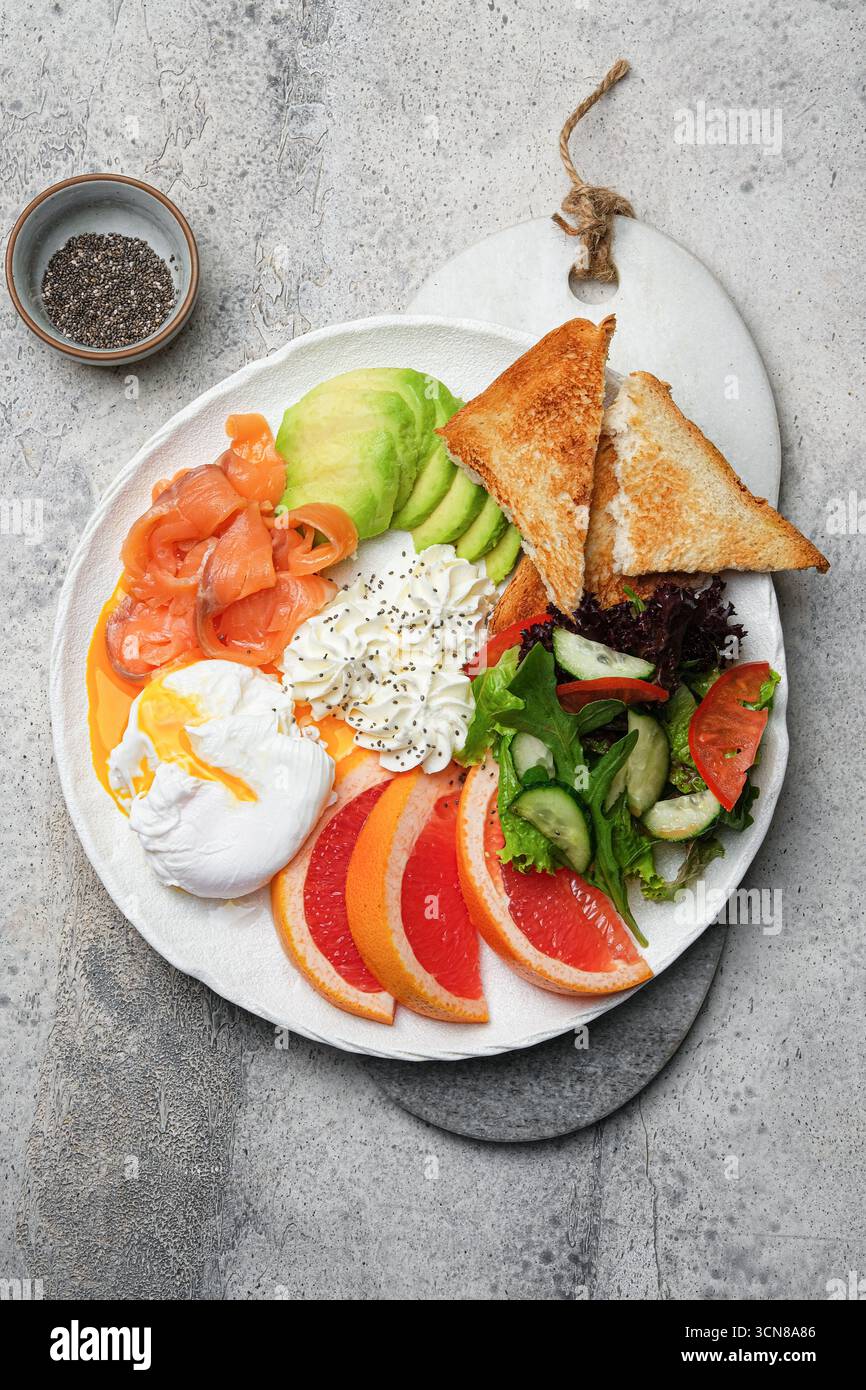 Ein gesunder Frühstücksteller mit Lachs, Avocado und einem perfekt pochierten Ei Stockfoto