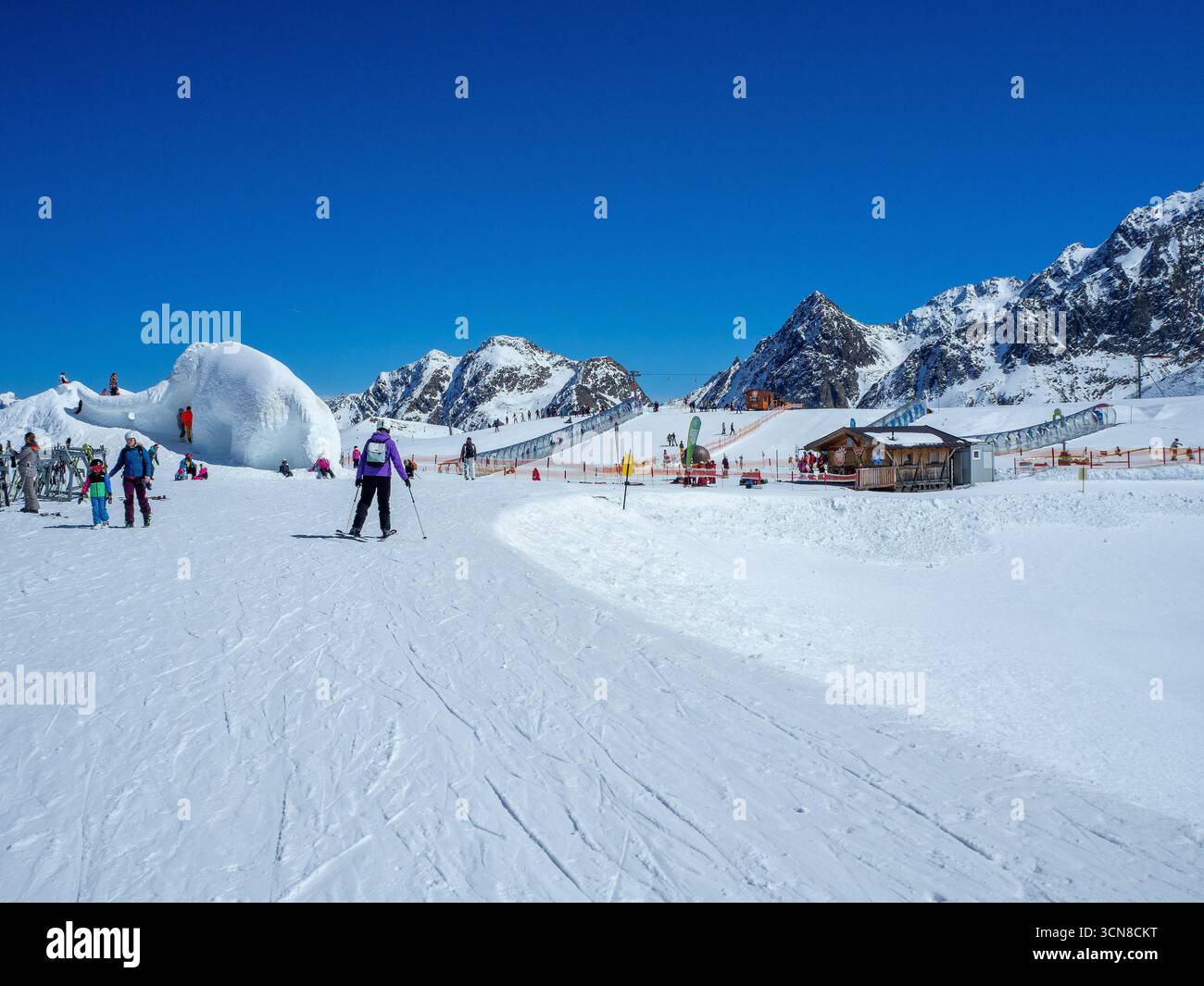 Stubai, Österreich - 8. April 2025: Skischule am Stubaier Gletscher mit Kinderschwimmpisten und Zauberteppichen (bewegliche Gehsteige) in transparenten Röhren. Skifahrer Stockfoto