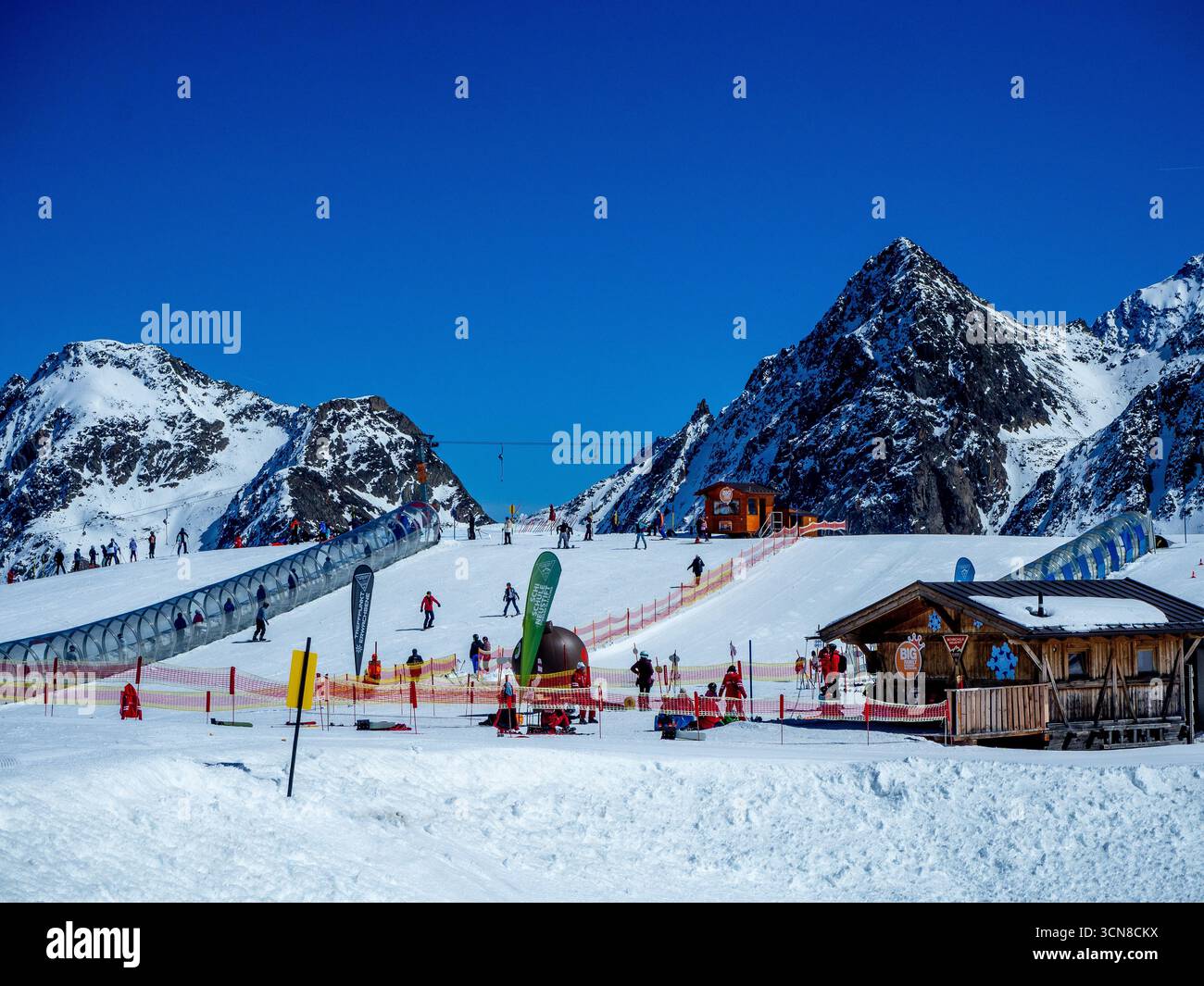 Stubai, Österreich - 8. April 2025: Skischule am Stubaier Gletscher mit leichten Kinderhängen mit Zauberteppichen (bewegliche Gehsteige) in transparenten Röhren Stockfoto