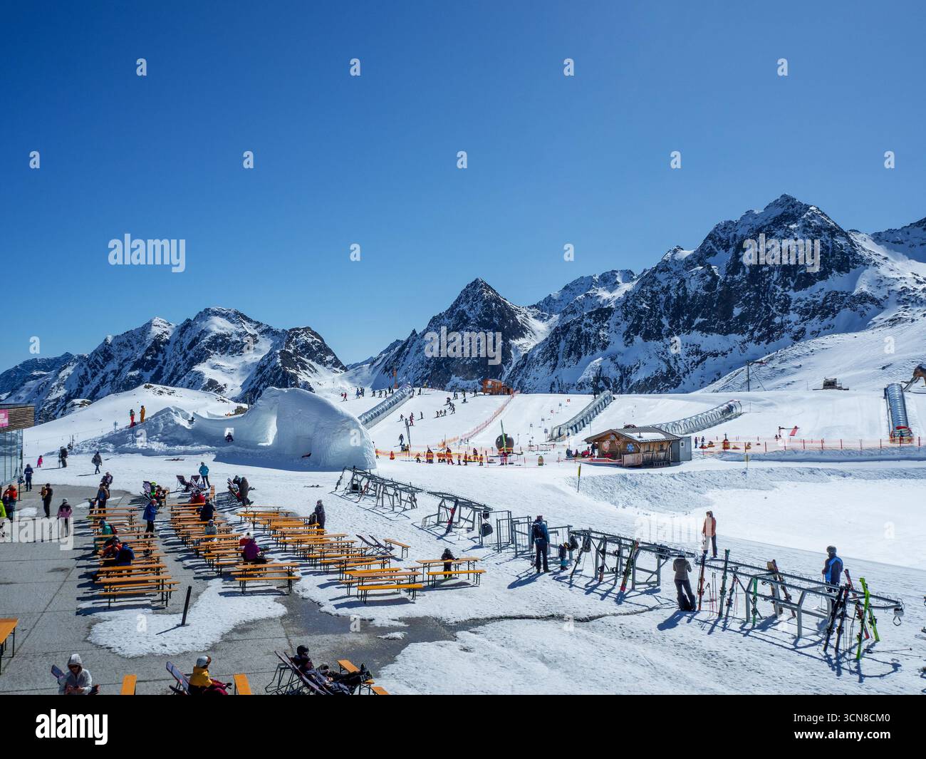 Stubai, Österreich - 8. April 2025: Skischule am Stubaier Gletscher mit Kinderschwimmpisten und Zauberteppichen (bewegliche Gehsteige) in transparenten Röhren. Skifahrer Stockfoto