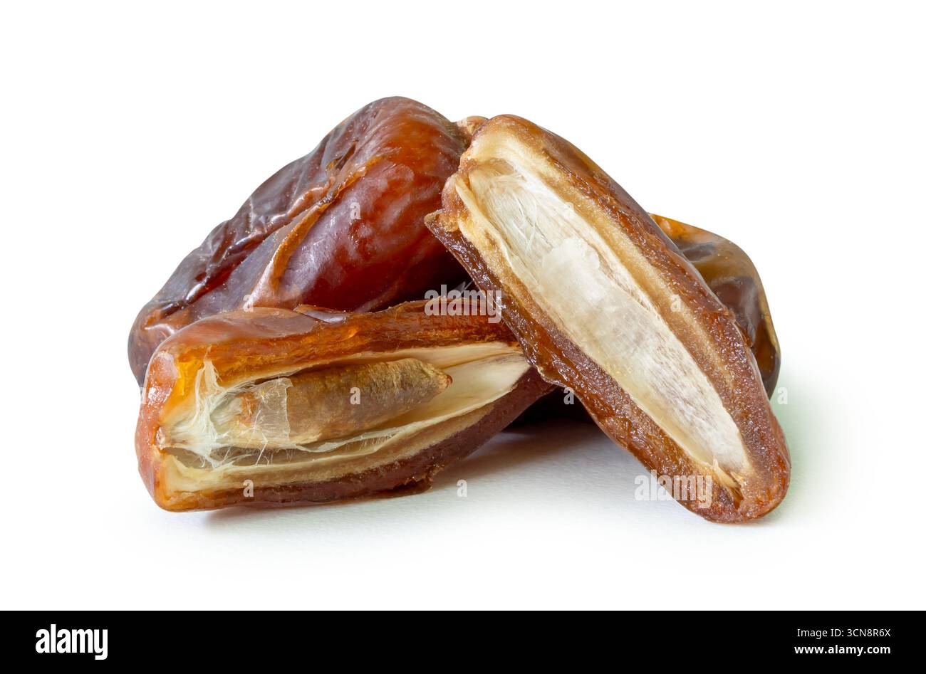 Reife getrocknete Dattelpalmfrüchte mit Hälften im Stapel sind auf weißem Hintergrund mit Schnittpfad isoliert. Das Konzept der iftar-Nahrung im Ramadan-Monat Stockfoto