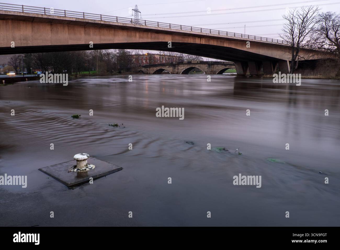 Der Fluss Aire an der Ferrybridge ist von Hochwasser geschwollen und fließt unter modernen und historischen Brücken Stockfoto