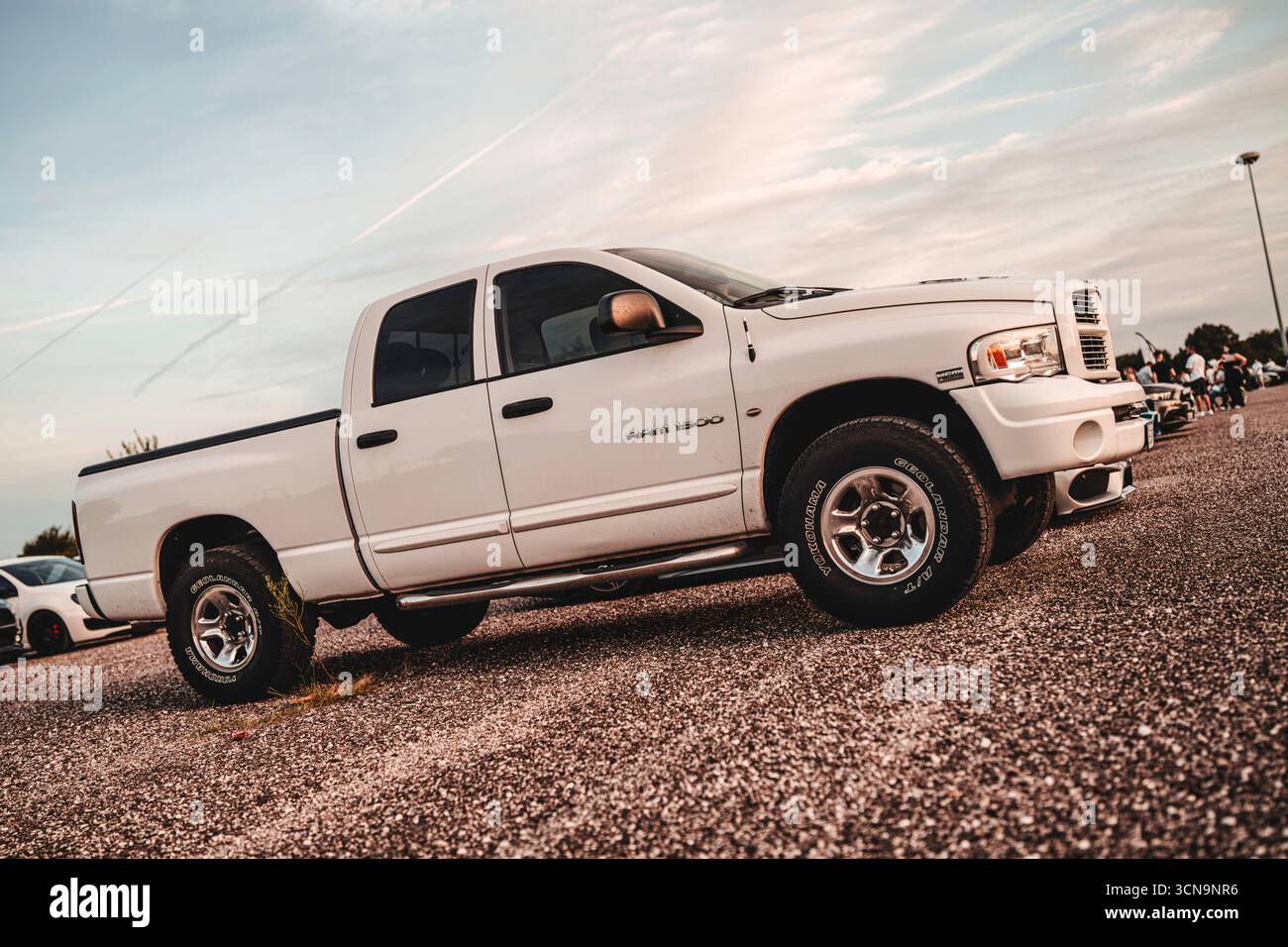 Mailand, italien 20. september 2025: Weißer Dodge RAM 1500 Pickup Truck steht auf einem Schotterparkplatz während eines Outdoor-Autotreffens und zeigt seine robuste d Stockfoto