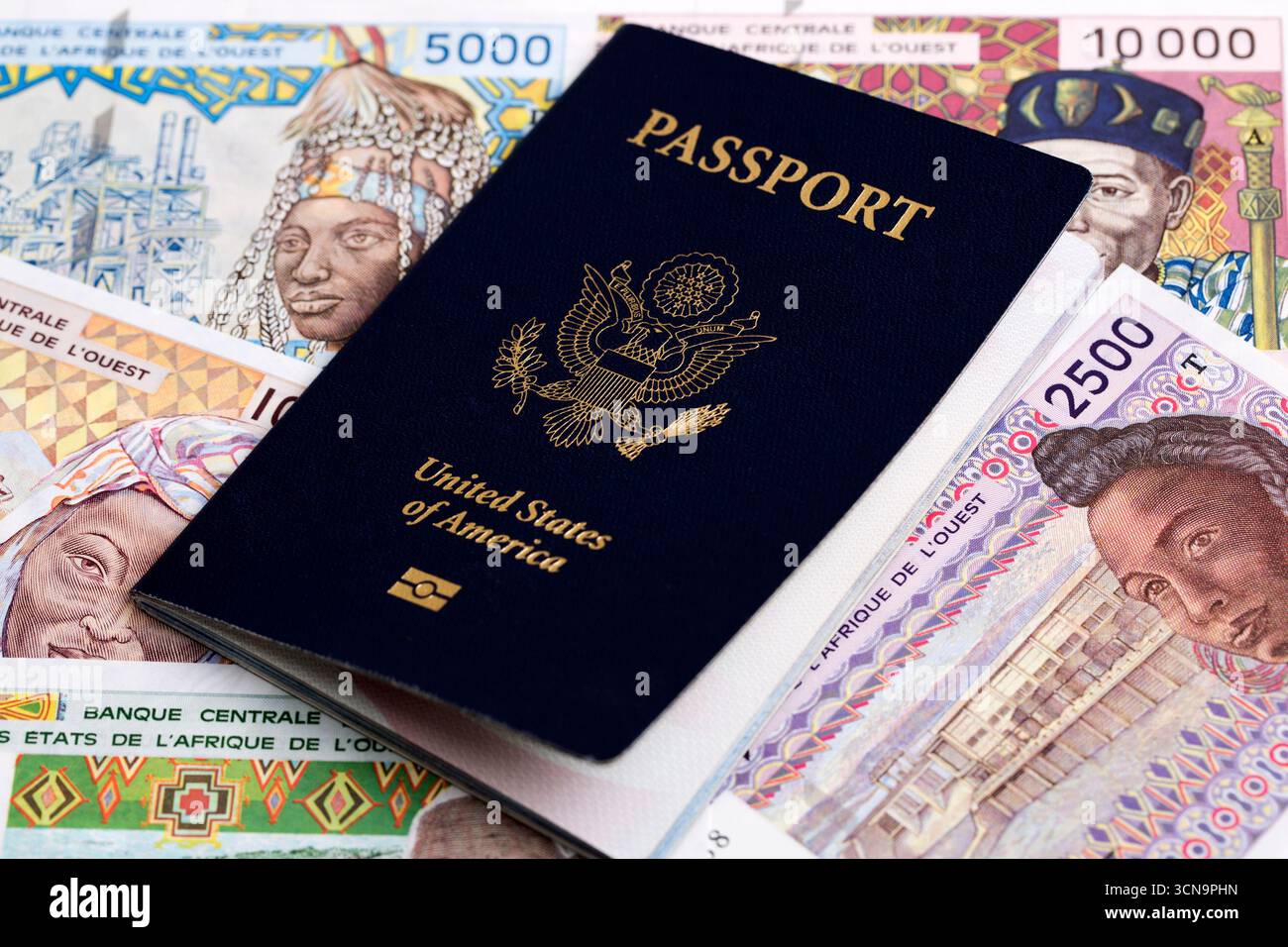 Amerikanischer Pass auf westafrikanisches Geld - Franc Stockfoto