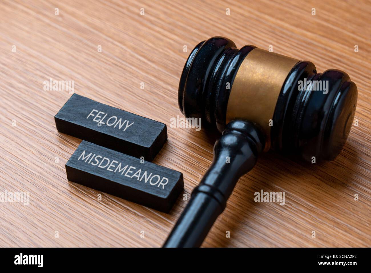 Ein richterlicher Hammer neben Holzblöcken mit der Aufschrift "Verbrechen und Vergehen". Rechtsbegriffe, Strafanzeige und richterliche Konzepte im Rechts- und Justizkonzept. Stockfoto