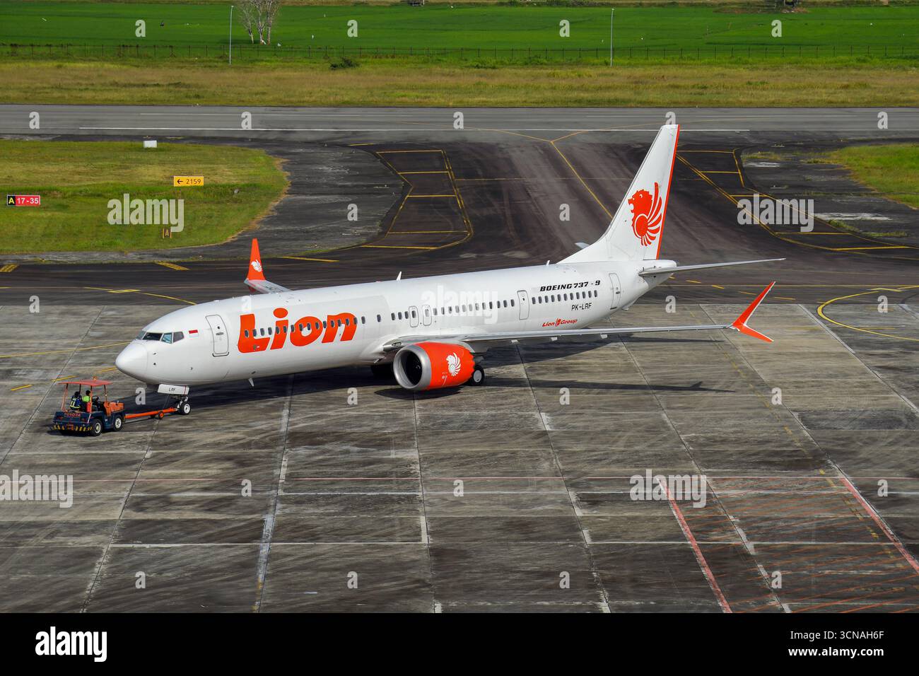 Die Boeing 737 Dash 9 von Lion Air wird mit einem roten Pushback-Auto zurückgeschoben. Lion Air ist eine Billigfluggesellschaft in Indonesien. Stockfoto