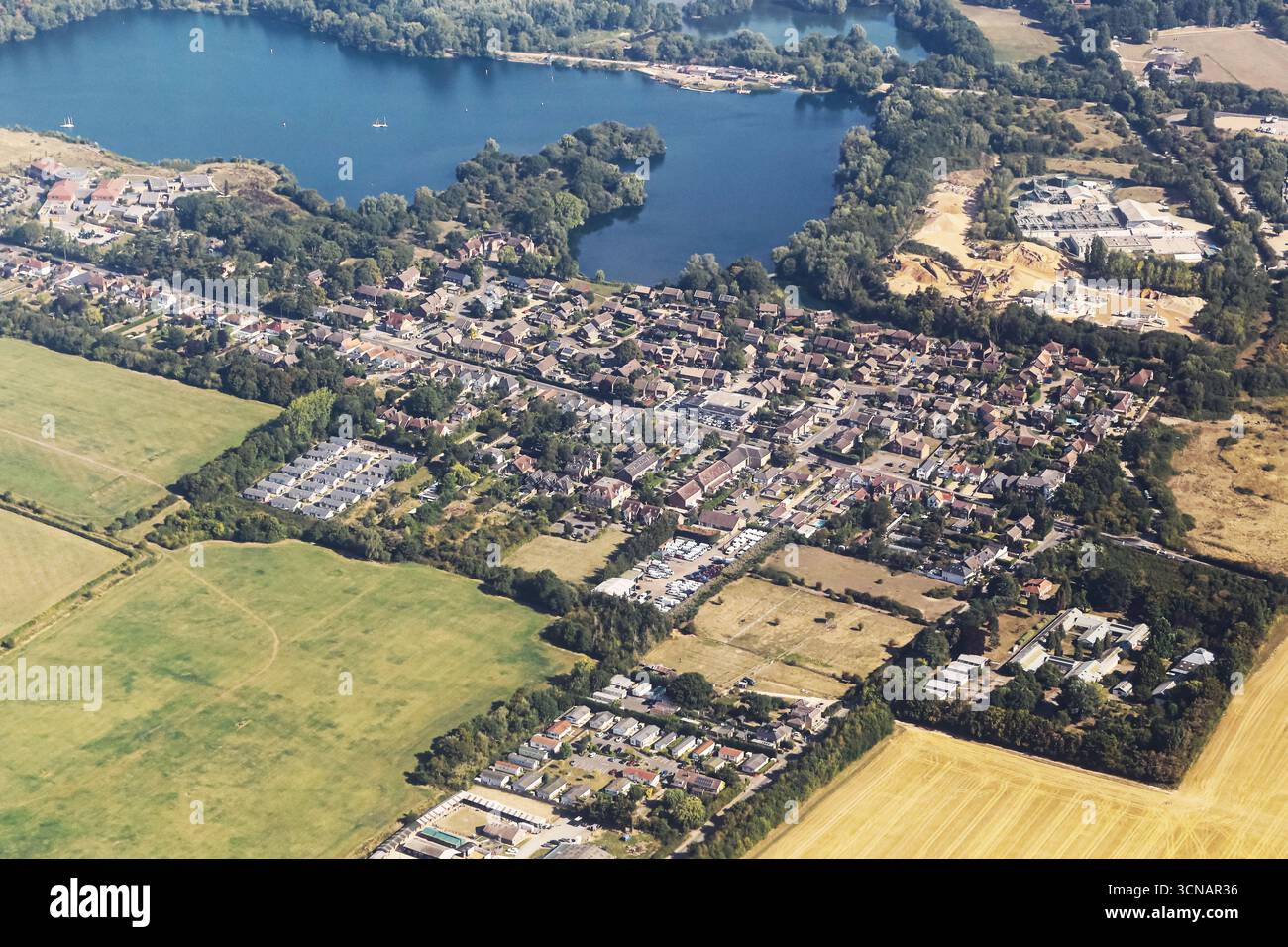 Blick aus der Vogelperspektive auf Stadt und Landschaft. Städtische und ländliche Landschaft mit Häusern, Feldern und Natur. Wohngebiet von oben. Kontrast der Architektur. Stockfoto