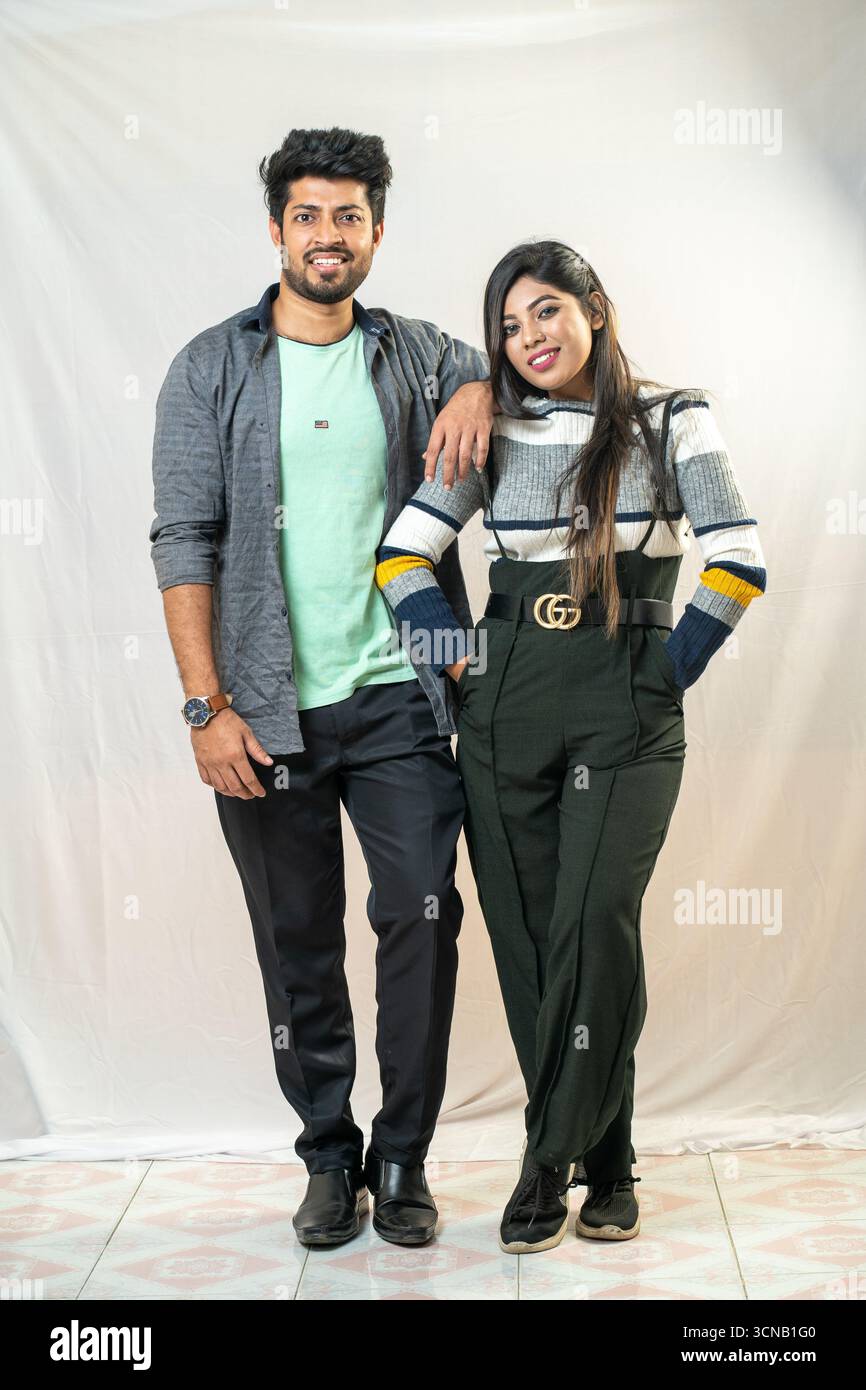 Ein junges Paar posiert mit einer entspannten und liebevollen Umarmung. Zwangloses und stilvolles Paar - Studio Portrait. Stockfoto