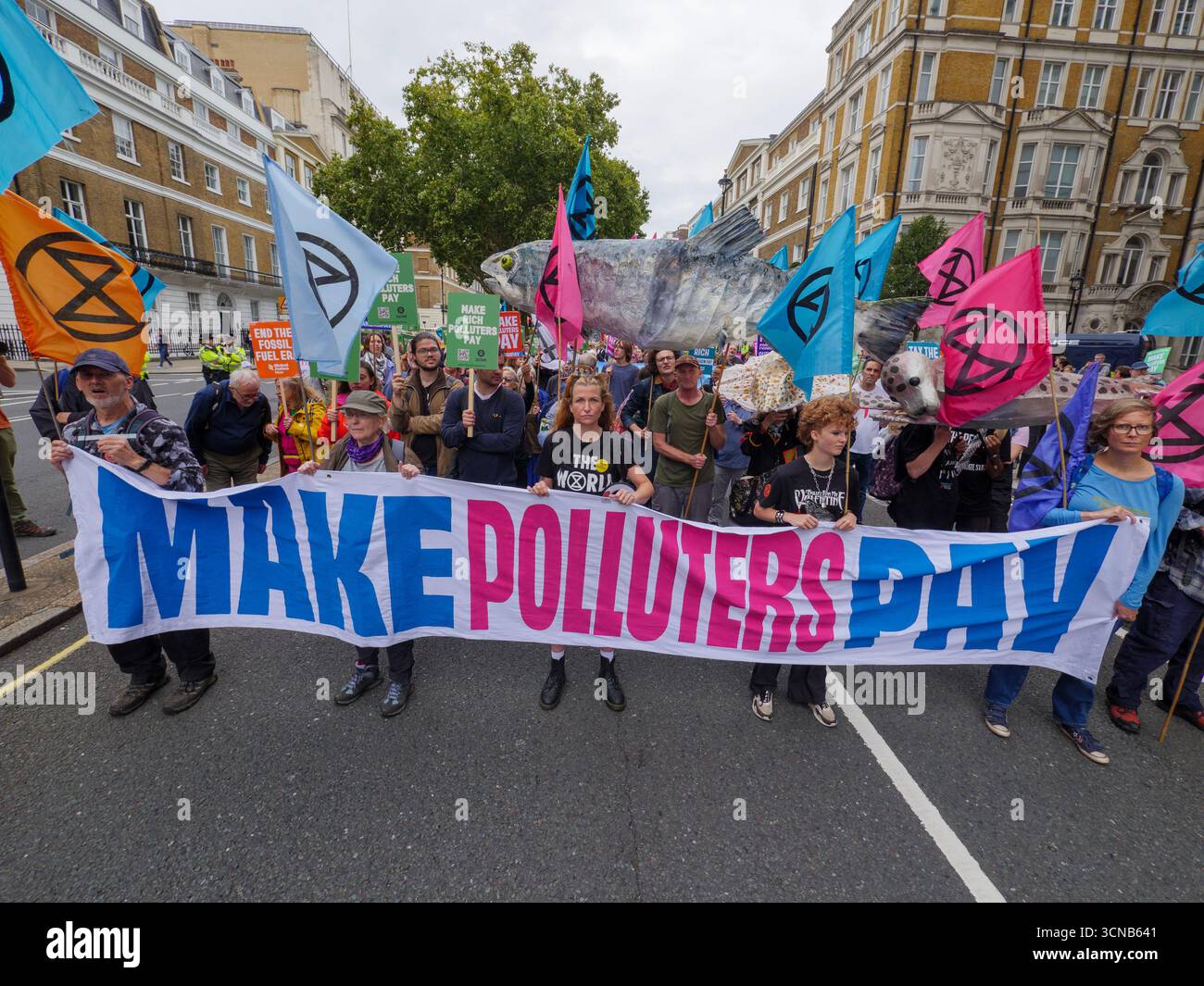 20. September 2025, Portland Place, London, Vereinigtes Königreich. Demonstranten mit Plakaten beim „Make They Pay“-marsch im Zentrum von London. Die Kampagne befasst sich mit Klimaungerechtigkeit und umfasst Demonstranten von Extinction Rebellion, Scientist Rebellion und Stay Grounded Stockfoto