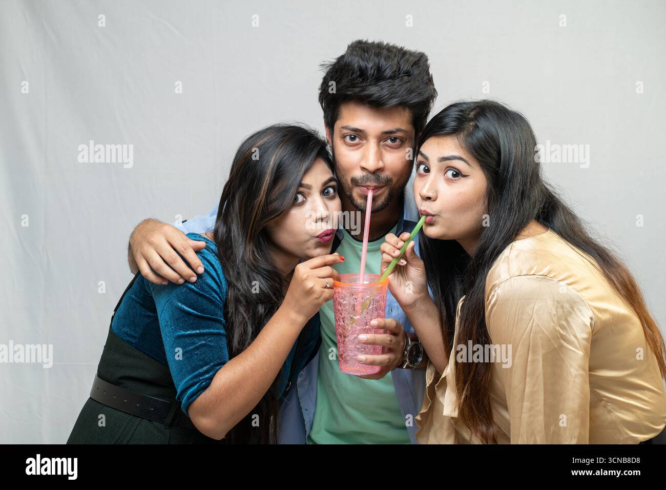 Drei junge Freunde teilen sich einen Drink Stockfoto