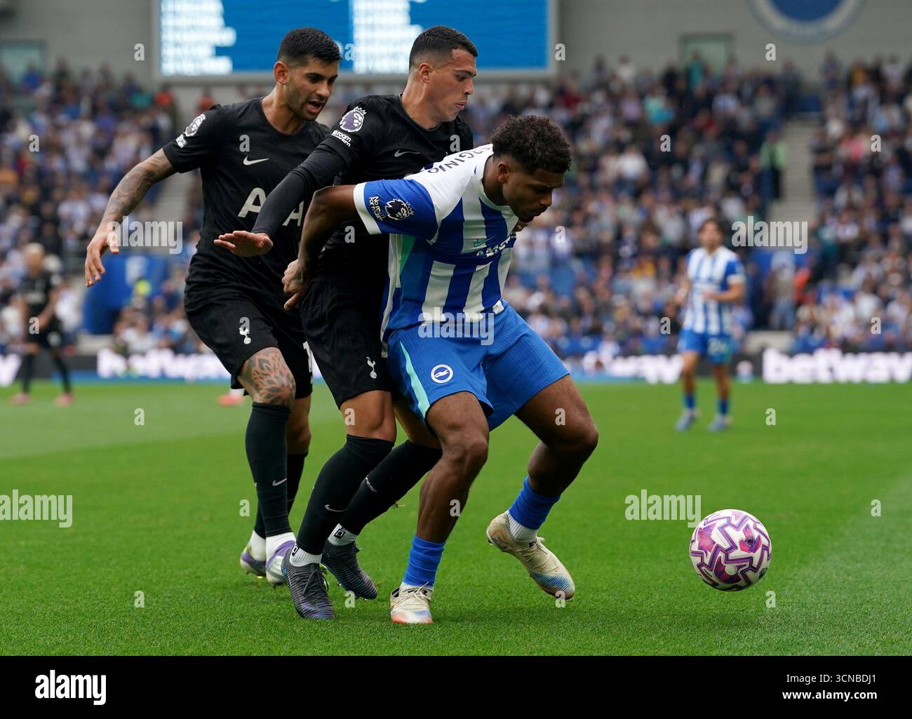 Brighton und Hove Albions Georginio Rutter (rechts) kämpfen um den Ball mit Tottenham Hotspurs Pedro Porro (Mitte) und Tottenham Hotspurs Cristian Romero (links) während des Premier League-Spiels im American Express Stadium in Brighton. Bilddatum: Samstag, 20. September 2025. Stockfoto