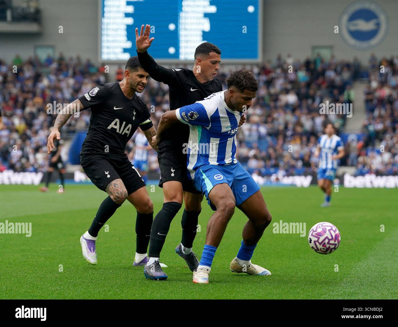 Brighton und Hove Albions Georginio Rutter (rechts) kämpfen um den Ball mit Tottenham Hotspurs Pedro Porro (Mitte) und Tottenham Hotspurs Cristian Romero (links) während des Premier League-Spiels im American Express Stadium in Brighton. Bilddatum: Samstag, 20. September 2025. Stockfoto
