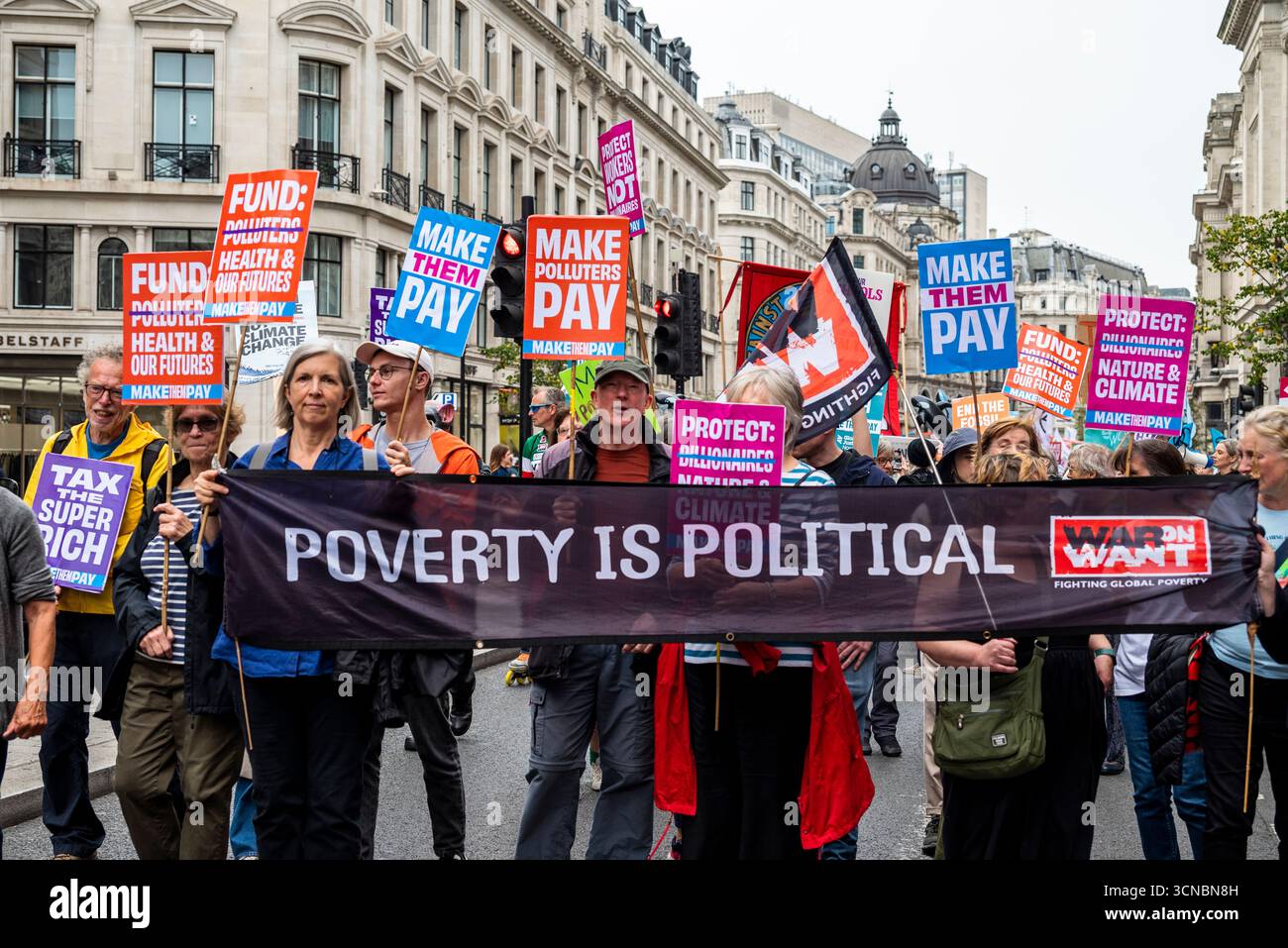 Die Demonstranten tragen das Banner "Armut ist politisch", lassen sie Marsch zahlen und fordern die Regierung auf, die Superreichen zu besteuern, Arbeiter zu schützen und nicht Milliardäre A. Stockfoto