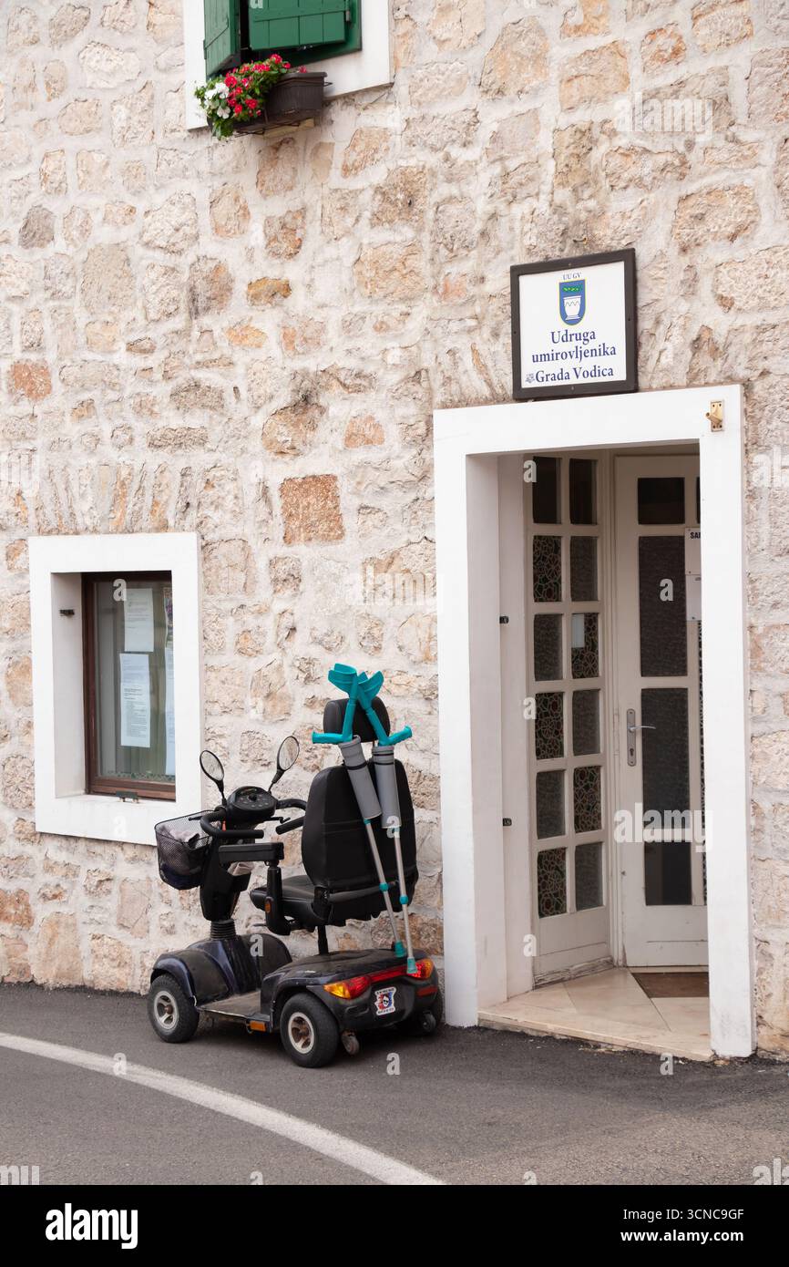 Vodice, Kroatien - 7. September 2025: Seniorenmobil mit vier Rädern und zwei Krücken parkten auf der Straße vor dem Verband von pe Stockfoto