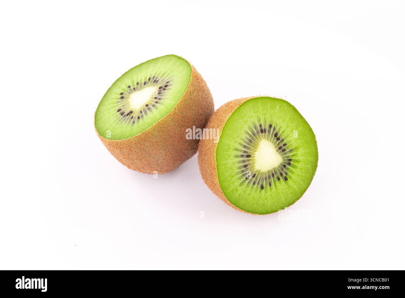 Zwei Kiwis werden in zwei Hälften geschnitten und auf einem weißen Hintergrund platziert. Die Kiwis sind grün und haben schwarze Samen Stockfoto