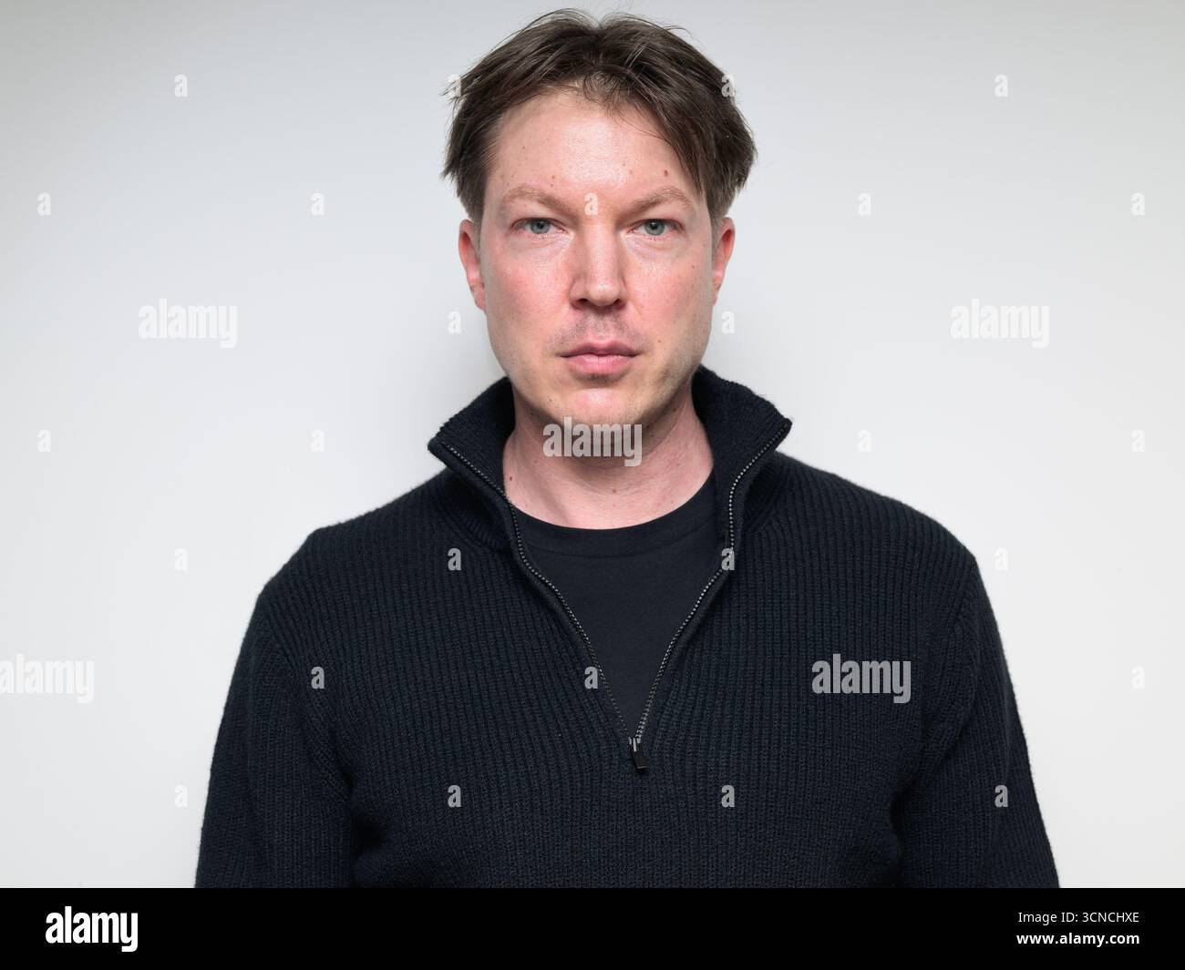 Skandinavischer mittelgroßer Mann im schwarzen Pullover-Porträt vor weißem Studiohintergrund, der in die Kamera schaut Stockfoto