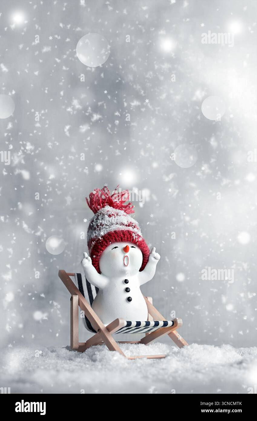 Ein kleiner Schneemänner auf der Sonne länger in Hüllen auf Schnee im Winter. Festlicher Hintergrund mit einem lustigen Schneemann. Weihnachtskarte, Kopierraum. Stockfoto