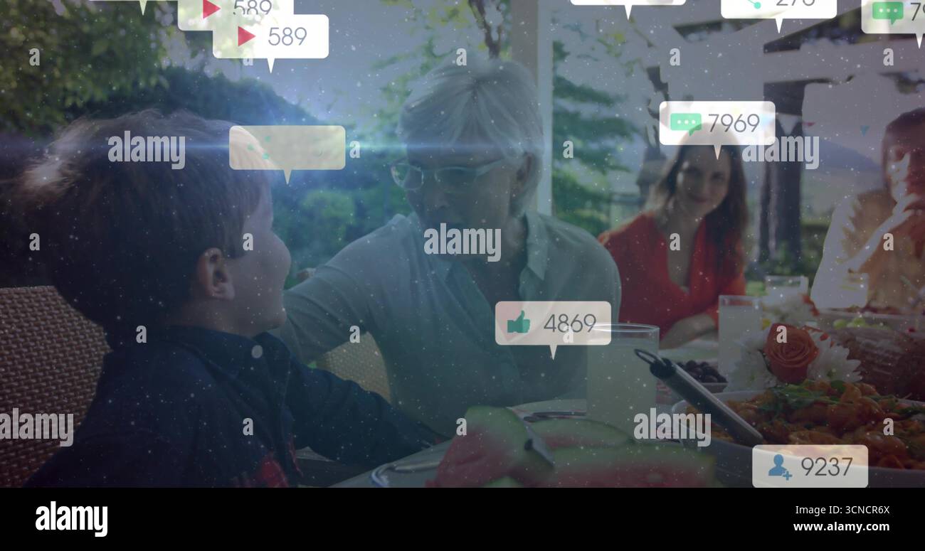 Familienessen auf der Gartenterrasse mit Wassermelonenscheiben und Social-Media-Ikonen Stockfoto