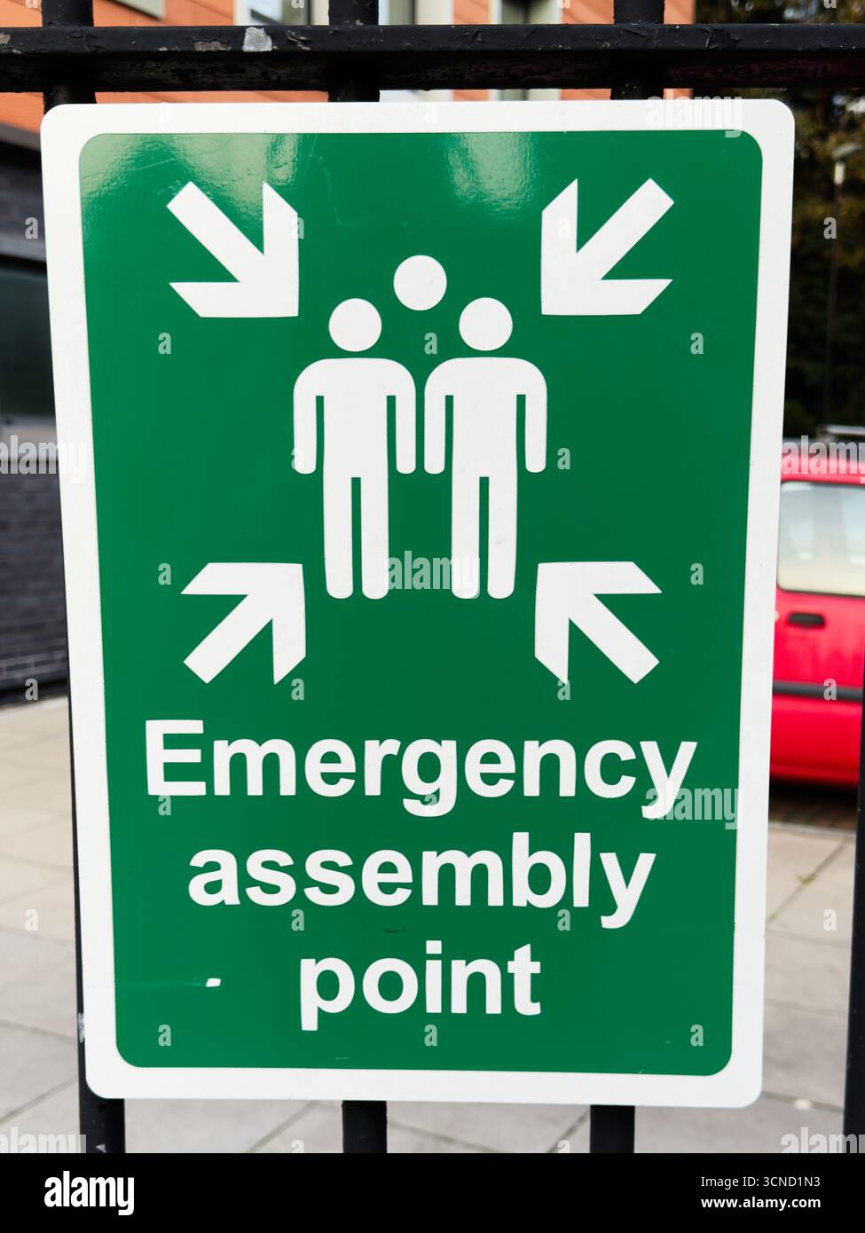 Grünes Schild für den Sammelpunkt für Notfälle am britischen Handelsstandort Stockfoto