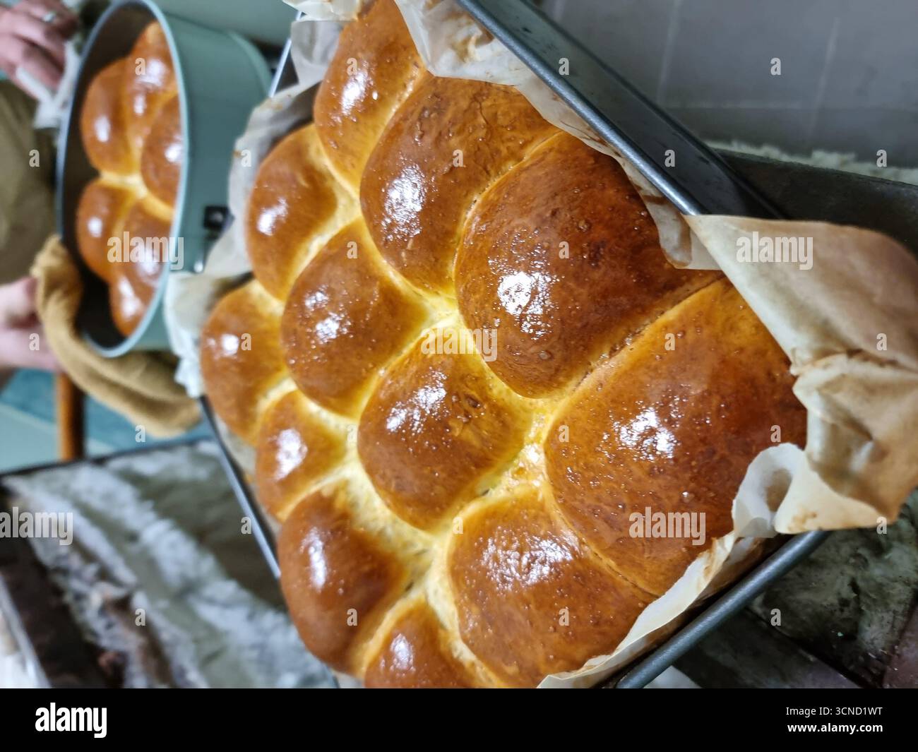 Eine Nahaufnahme goldbrauner Backwaren, frisch aus dem Ofen, verströmt Wärme und ein köstliches Aroma. Die knusprigen, schuppigen Krusten und das rustikale Aussehen Stockfoto