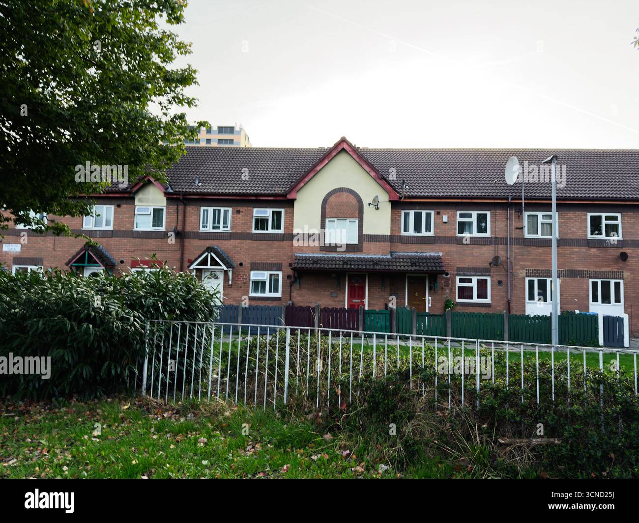 Gemauerte Stadthäuser mit Pfahlzäunen in einem Viertel von Manchester, Großbritannien Stockfoto