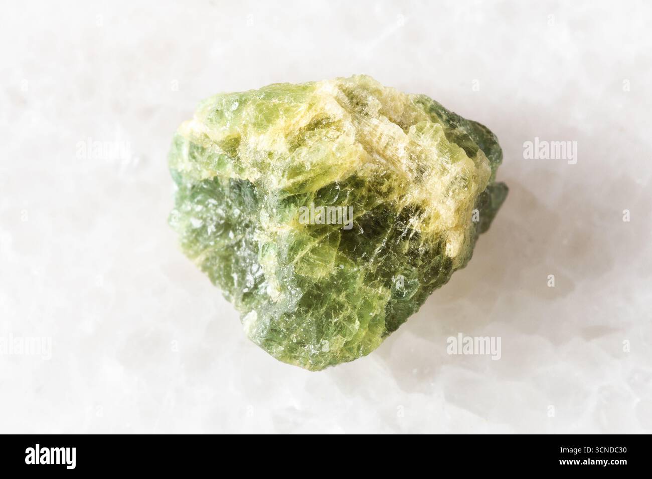 Probe eines rohen gelb grünen berylminerals auf weißem Marmorhintergrund aus nächster Nähe aus Tansania Stockfoto