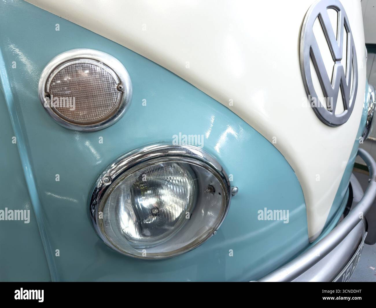 Nahaufnahme eines zweifarbigen VW-Vans in Blau und weiß mit klassischen Scheinwerfern und dem legendären VW-Emblem Stockfoto