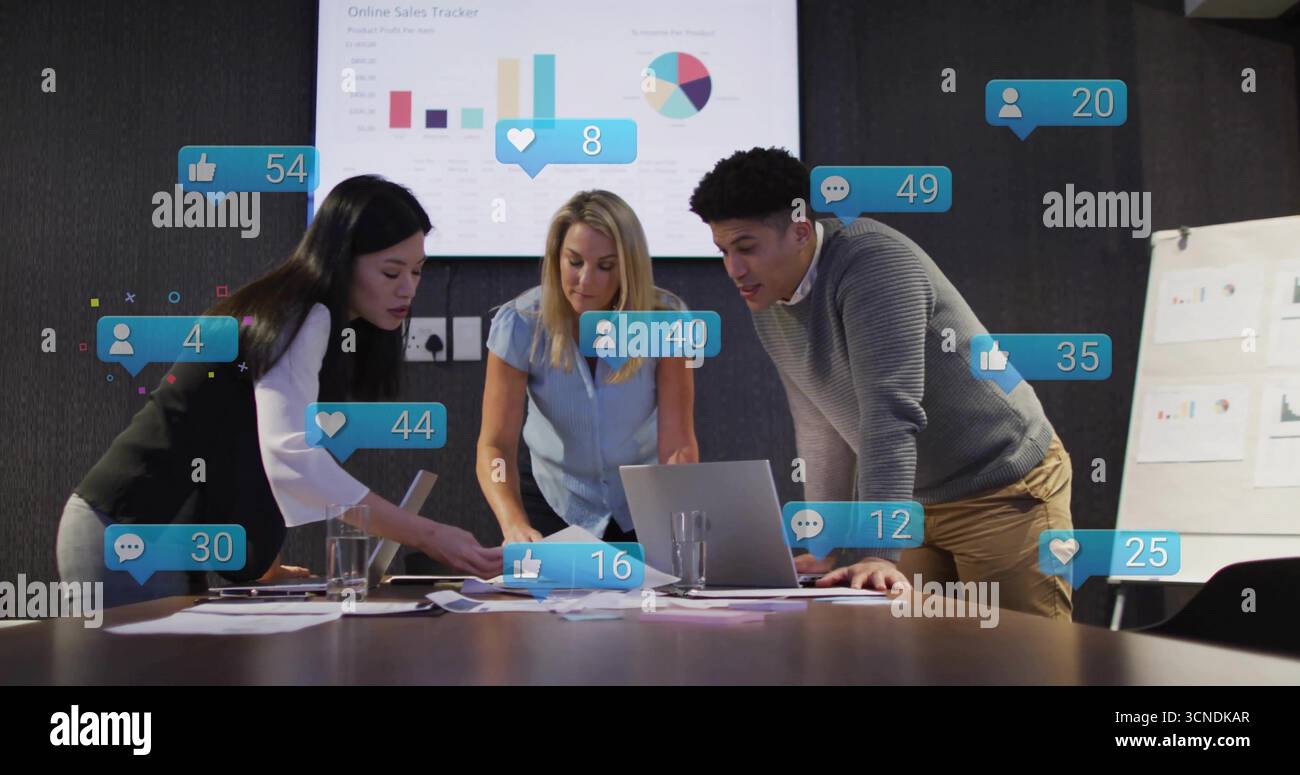 Drei Fachleute, die Verkaufskarten im Konferenzraum untersuchen, mit Laptop und Flipchart Stockfoto