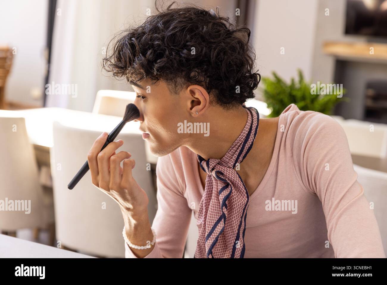 Make-up-Pinsel zum Auftragen von Make-up auf die Haut am Holztisch, Topfpflanze auf dem Sideboard Stockfoto