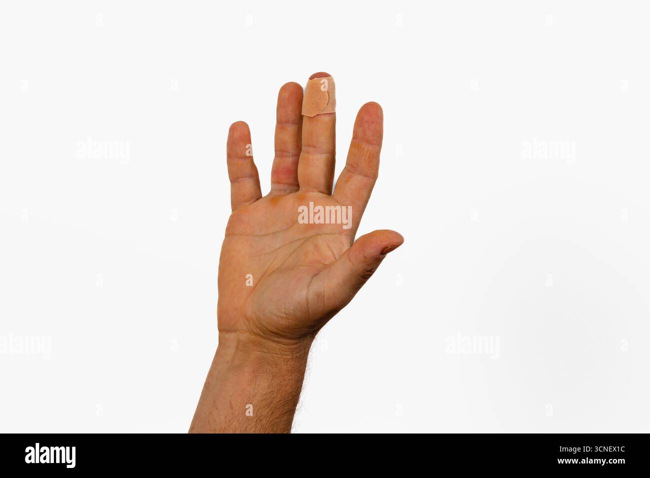 Eine Hand wird mit ausgestreckten Fingern angehoben und zeigt einen Verband an einem Finger. Die Hand hat einen natürlichen Hautton und der Hintergrund ist komplett weiß. Stockfoto