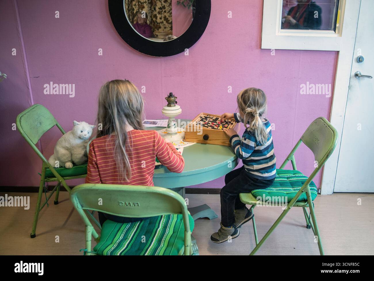 Zwei kleine Kinder sitzen an einem Tisch und spielen Spiele. Stockfoto