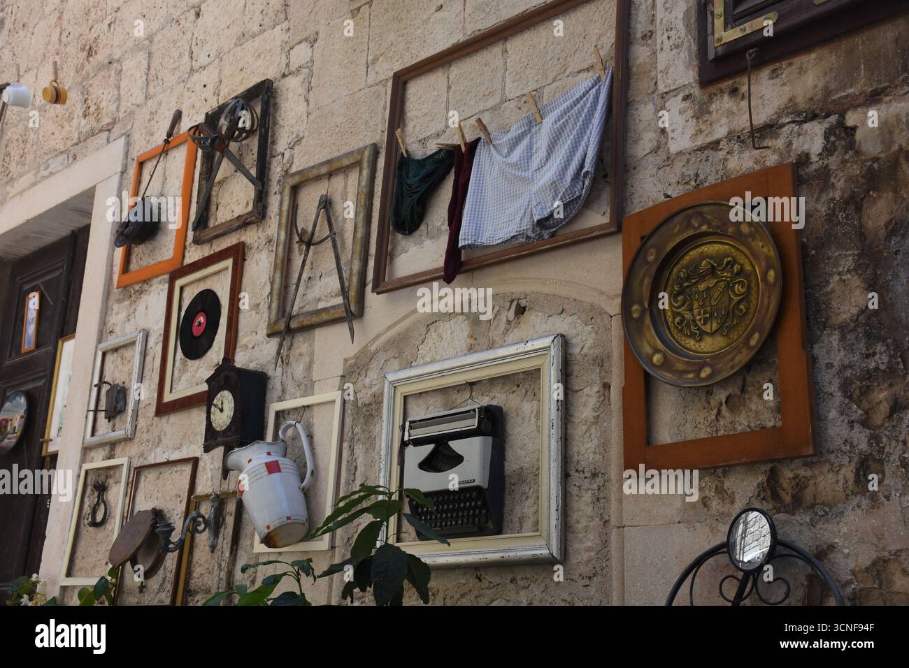 Die alten Objekte einer seltsamen Ausstellung in Korcula an einer Hauswand Stockfoto