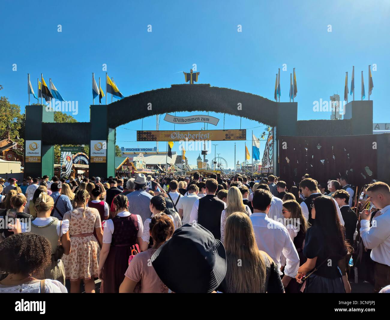 MÜNCHEN, DEUTSCHLAND - 20. SEPTEMBER 2025: Eintritt zum Oktoberfest oder Wiesn mit Menschenmassen, die die Theresienwiese überschwemmen. Stockfoto