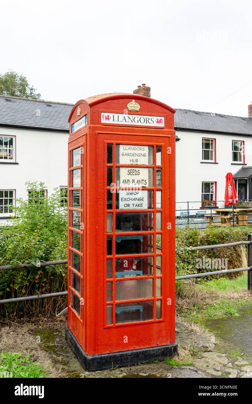 Alte redundante öffentliche rote Telefonkiosk, die als Community Exchange Point für Saatgut und Pflanzen mit Informationen in englischer und walisischer Sprache genutzt wurde Stockfoto