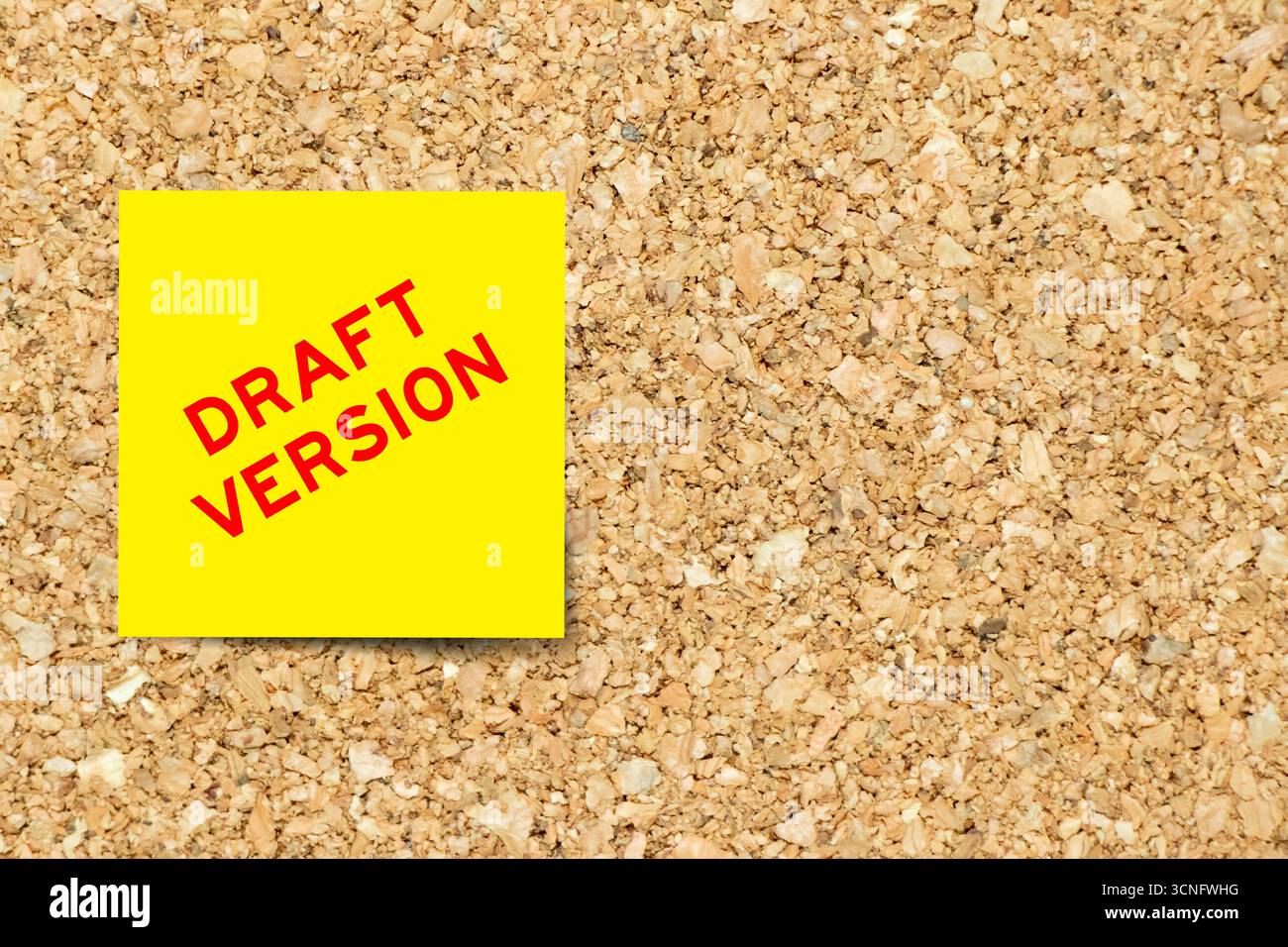 Gelbes Notizpapier mit Wortentwurf auf Korkbrett-Hintergrund mit Kopierraum Stockfoto