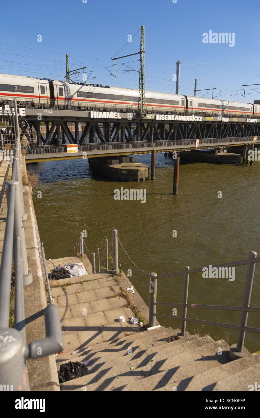 Heruntergekommene Treppe zum Oberehafen und Ericusgraben mit Blick auf die Oberhafenbrücke, über die ein ICE-Zug fährt, Hamburg Stockfoto