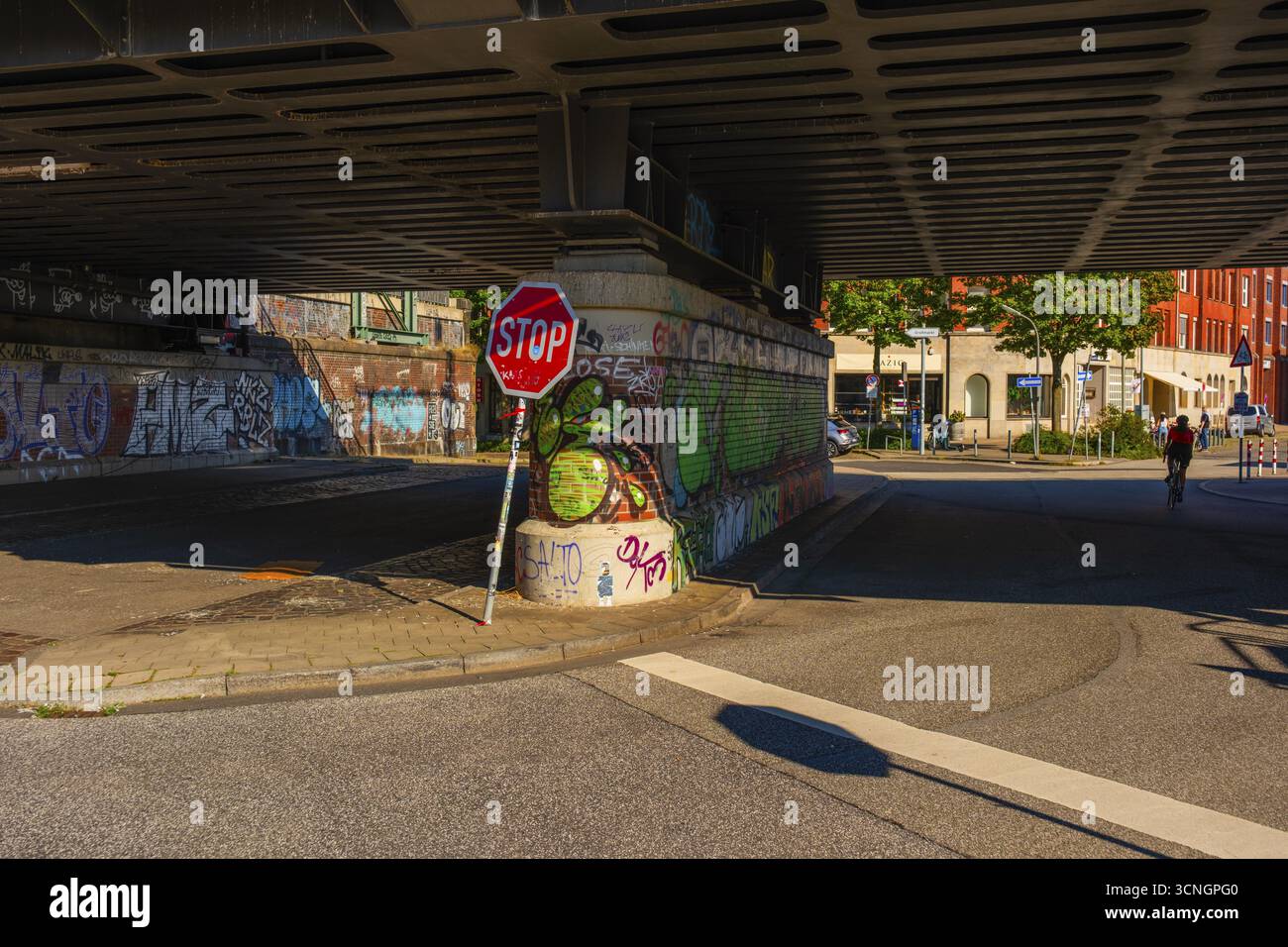 Blick auf Teile einer unter die Oberhafen-Brücke führenden Straße und auf das mit Graffiti gemalte Abutment, Menschen als Gnome, Hamburg, Deutschland Stockfoto