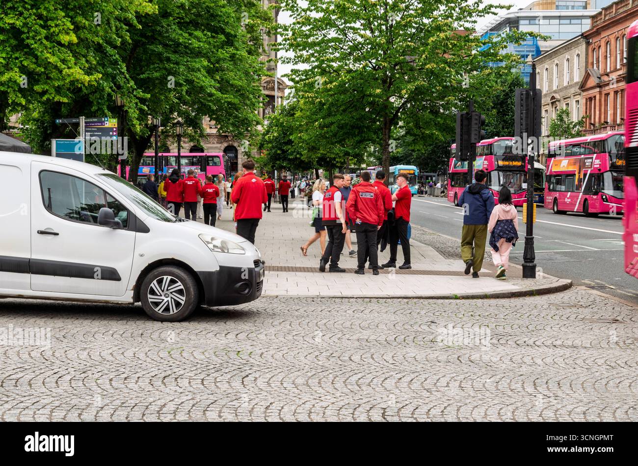 Belfast Co. Antrim 29. Juni 2025 - Tourleiter nähern sich Mitgliedern der Öffentlichkeit, um sie zu einer geführten Bustour durch Belfast zu überreden Stockfoto