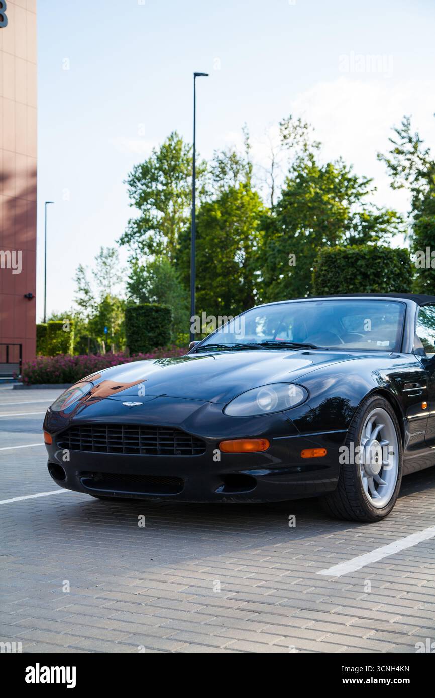 Vilnius, Litauen - 2025 17. 07.07.2017 - Klassisches Aston Martin DB7 in schwarz geparkt auf einem städtischen Grundstück bei Sonnenuntergang, Vorderperspektive Stockfoto