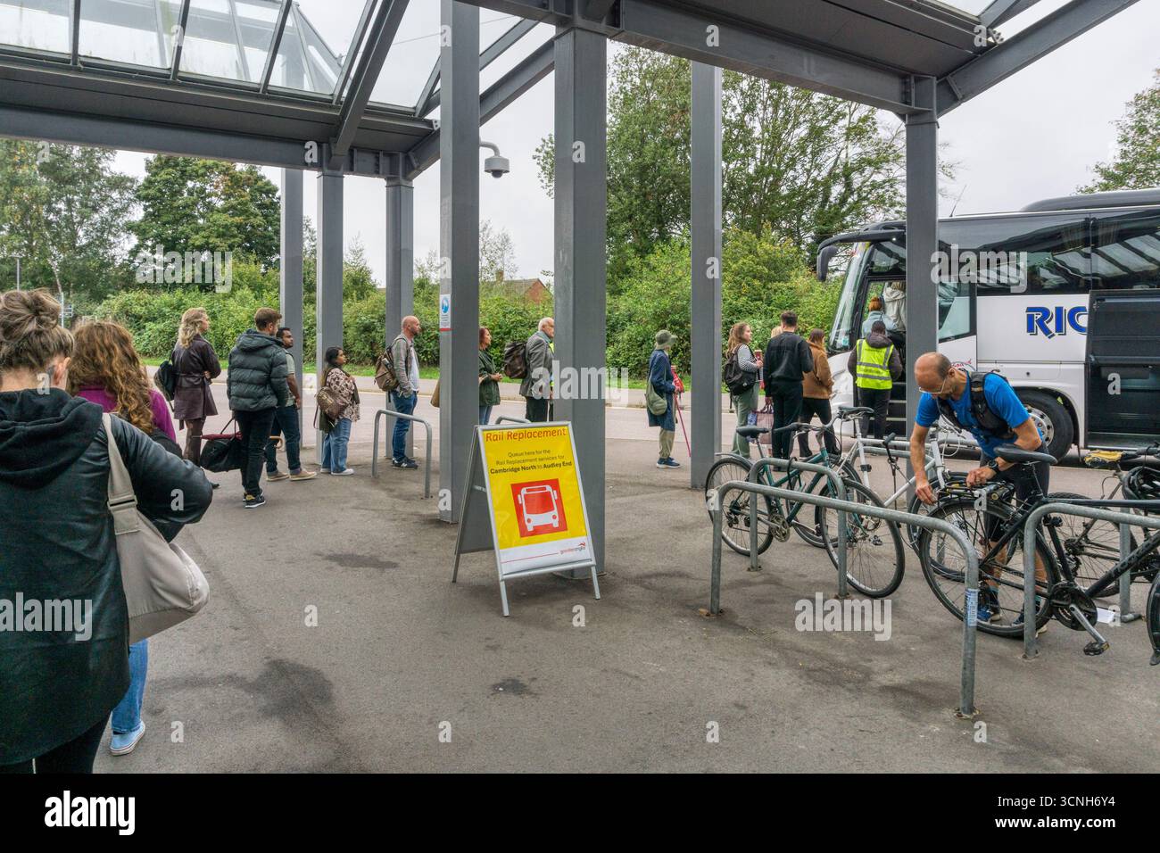 Leute, die vor dem Bahnhof Cambridge North für einen Schienenersatzservice, also einen Bus, anstehen. Stockfoto